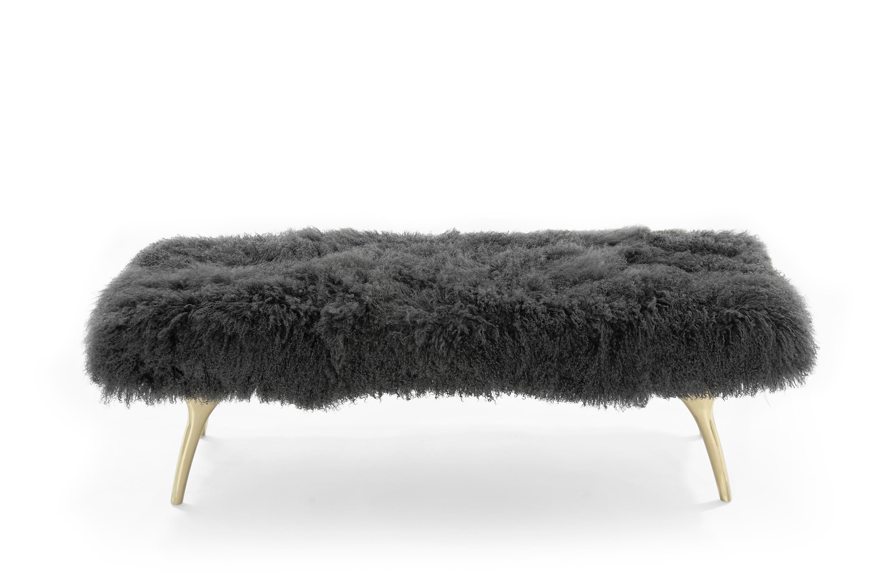 The Crescent Bench floats effortlessly, poised on brass fingertips. Inspired by 20th-century visionaries like Vladimir Kagan and Gio Ponti, this bench offers a unique perspective. The plush bench cushion is fully wrapped in charcoal Mongolian wool
