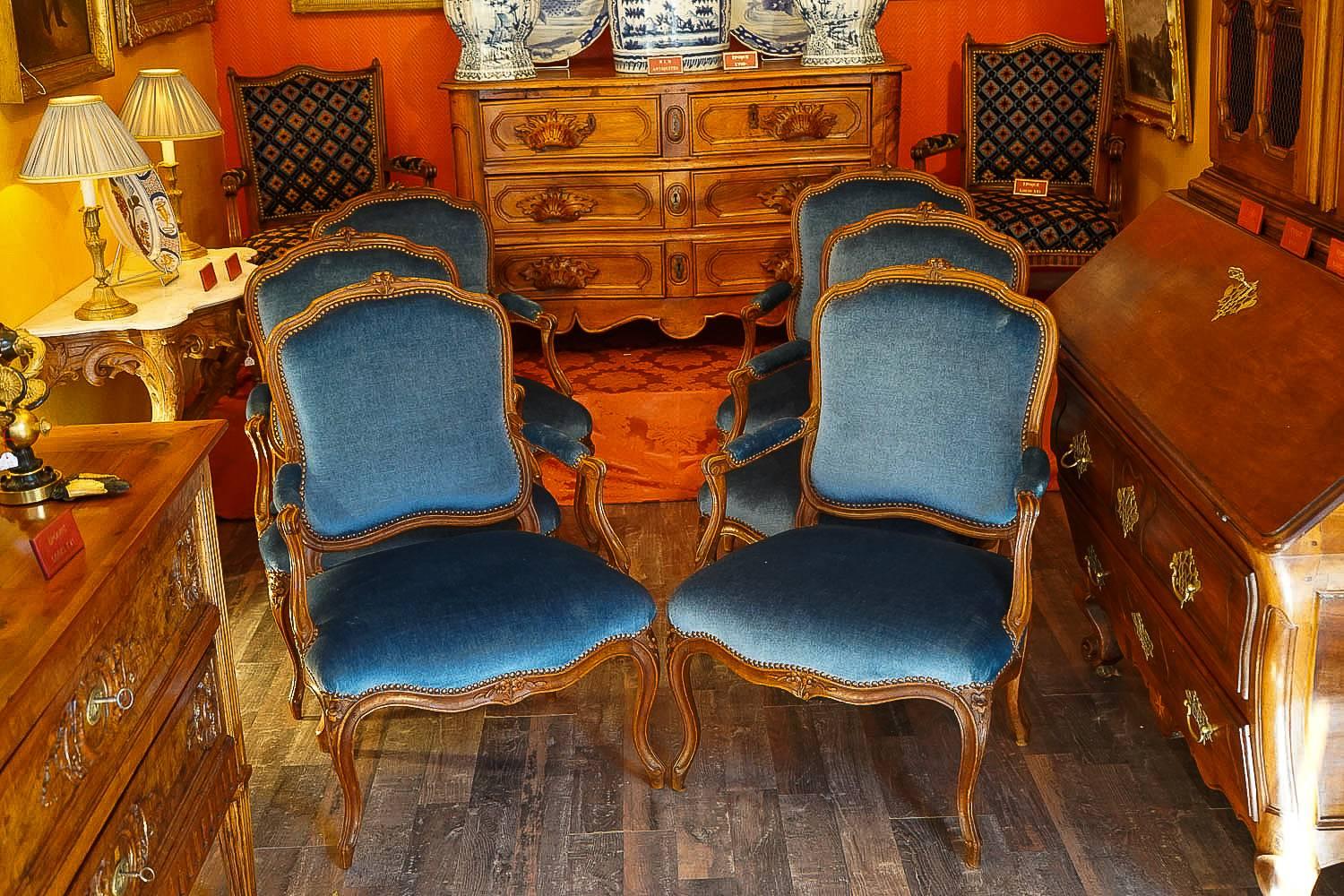 We are pleased to present you a beautiful et rare set of six large armchairs in beechwood with floral carving on its back and front seat.

Our armchairs are in excellent condition and there upholstered with a blue velour fabric.
In fine