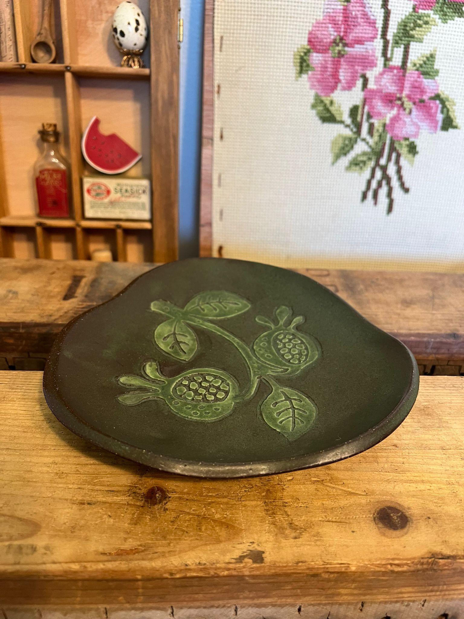 Brown and green mi century modern style Studio pottery. Stamped and adorned with floral design. Vintage Condition as pictured.Listing is for described item only.

Dimensions. 7”W ; 7”D ; 1”H