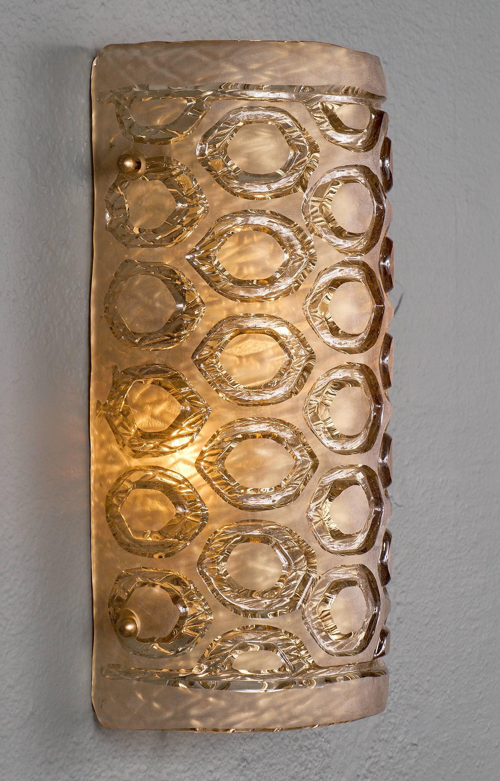 A pair of Murano glass sconces of frosted glass with a geometric stamped pattern. We love the size and dynamic curve of this pair. Each sconce requires two medium-base bulbs up to 60 watts each. Wired to meet US standards.

This pair is currently