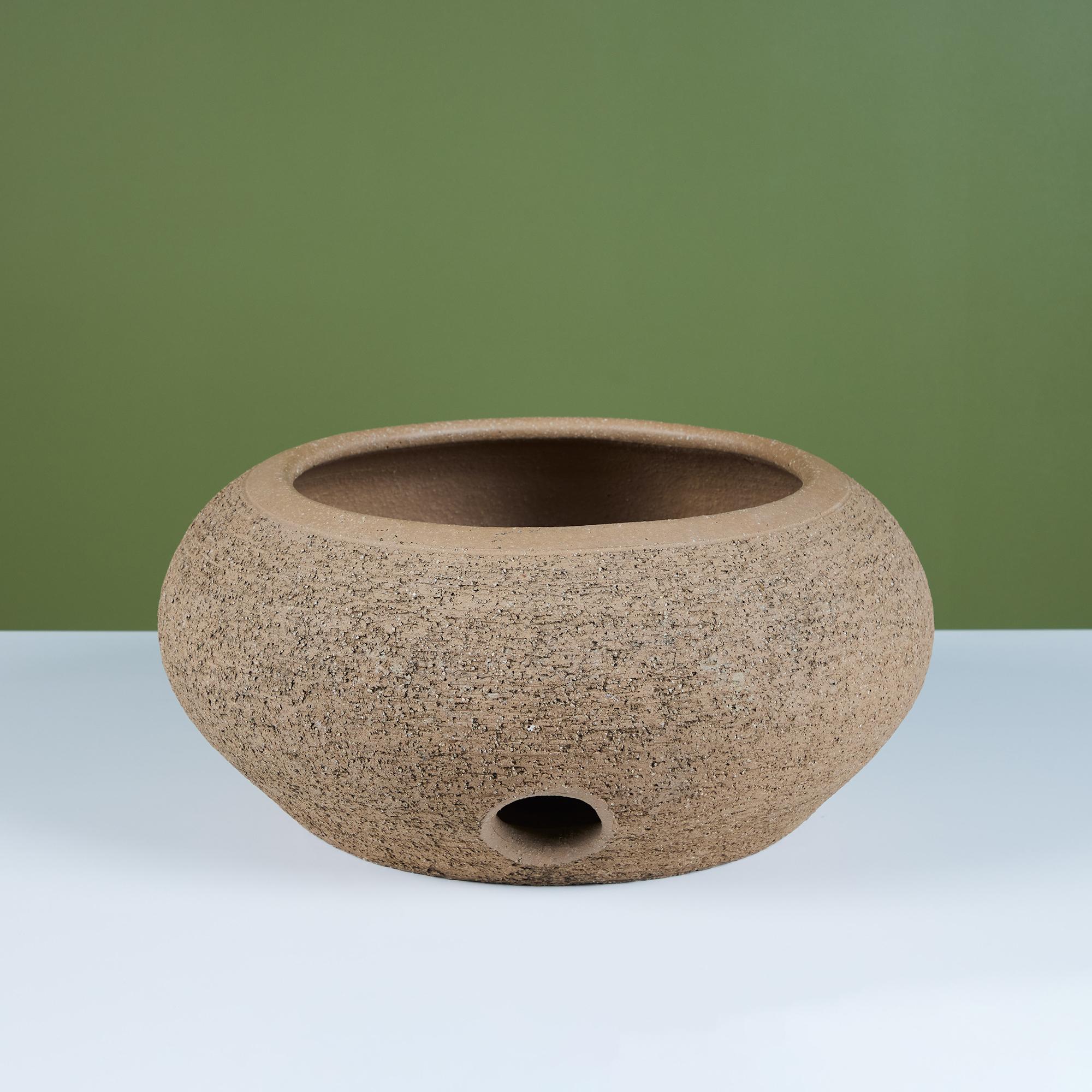 Round hand formed pot by California artist Stan Bitters for Hans Sumpf, c.1970s, USA. This clay pot features a raised center in which to wrap a garden hose around. It's a discreet and beautiful way to store your hose.
Signed on the