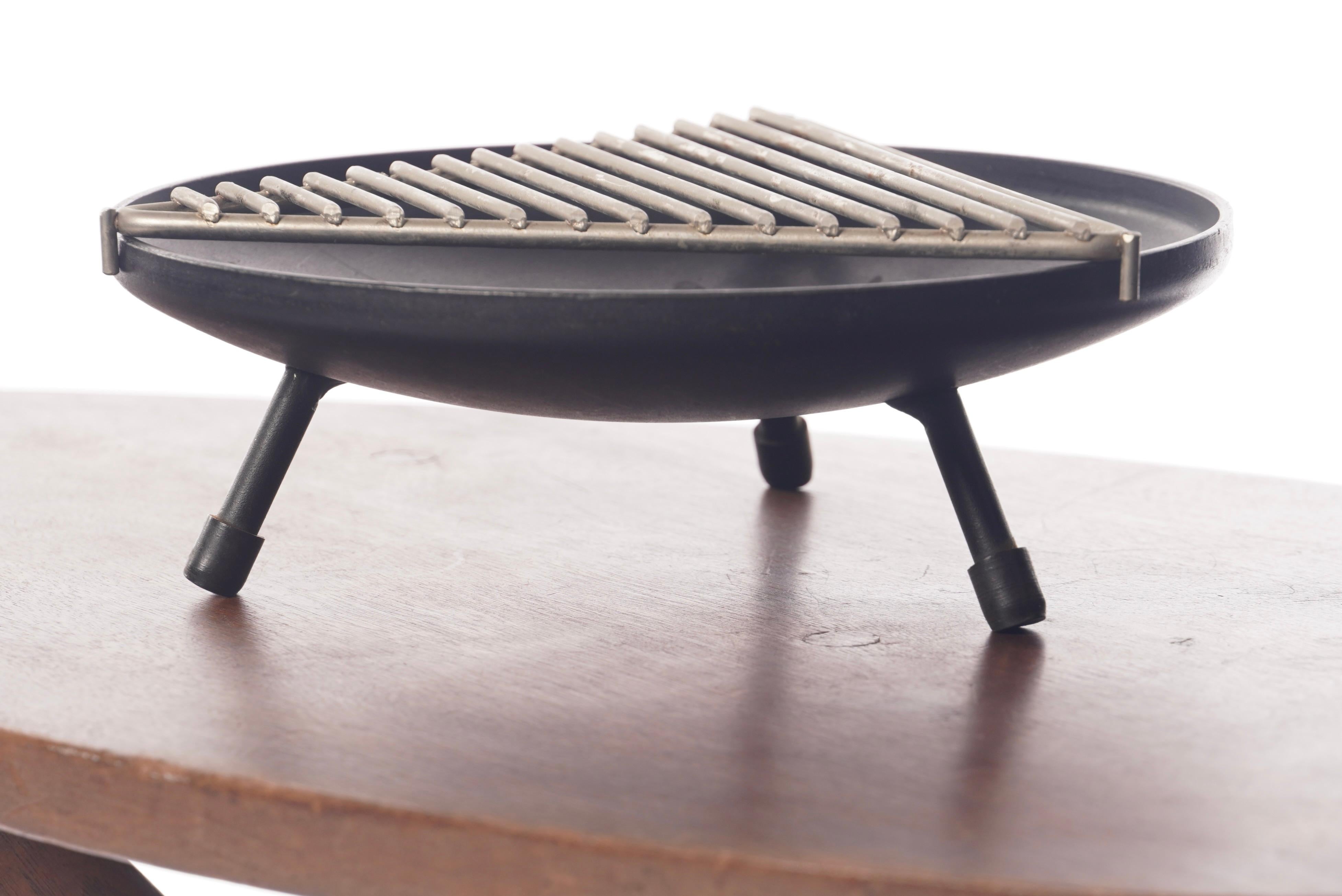 Ashtray circa 1950s by designer Stan Hawk for his company Hawk House of California. Round iron body with three legs capped with rubber feet and a chromed triangular grind that is removable.  