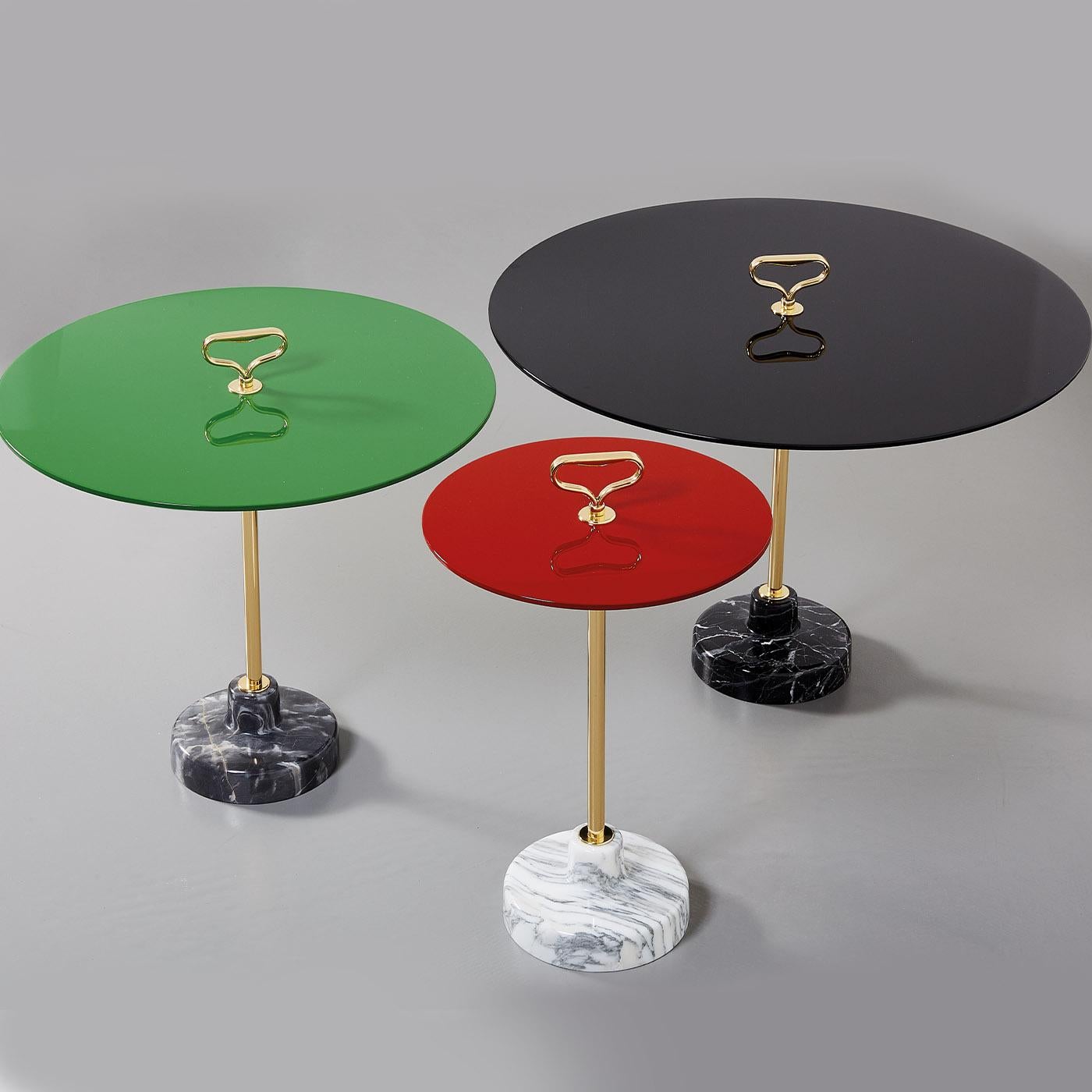 An exquisite design created by Ignazio Gardella for the Stand Collection of side tables, this gorgeous piece is distinguished by a vintage-inspired combination of hues. Resting on a black marble base, it features a brass stem topped with a practical