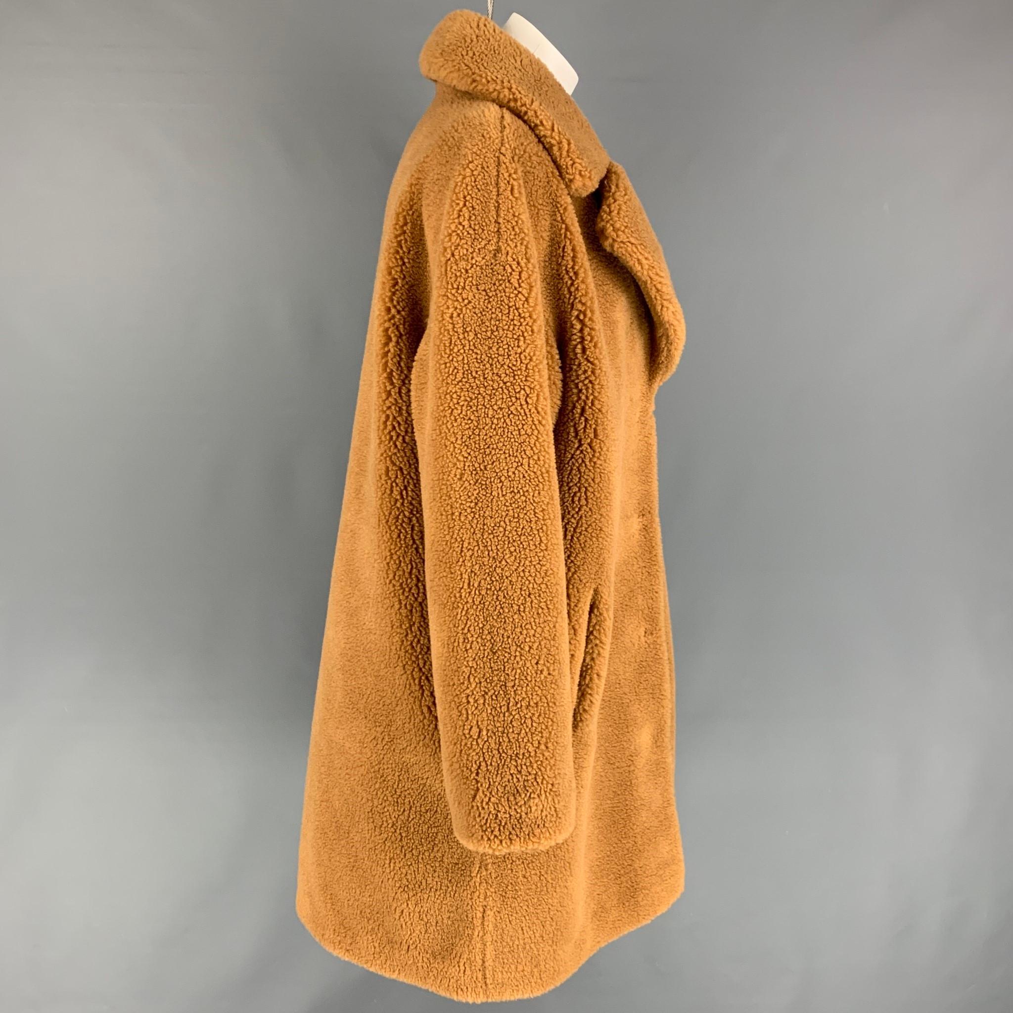 STAND STUDIO coat comes in a tan faux fur featuring a notch lapel, slit pockets, and a hidden snap button closure. 

Very Good Pre-Owned Condition.
Marked: 42

Measurements:

Shoulder: 23 in.
Bust: 46 in.
Sleeve: 24 in.
Length: 39.5 in. 