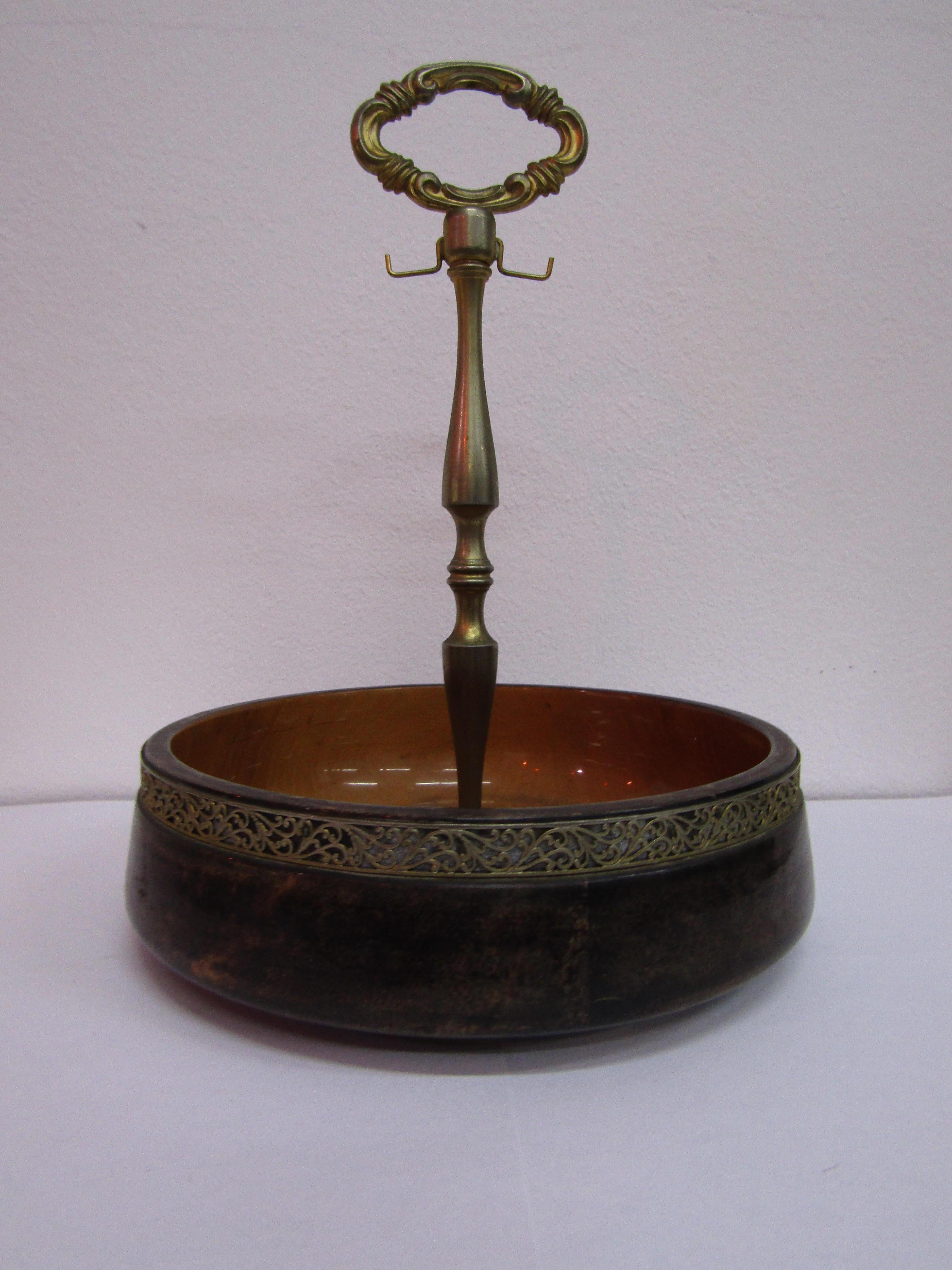 
Parchment wood bowl with handle and strip surrounding the brass bowl. The bowl still contains its original label (see photo).
The bowl was created by Aldo Tura in Italy in the mid-century period.


Aldo Tura was not an experimental furniture