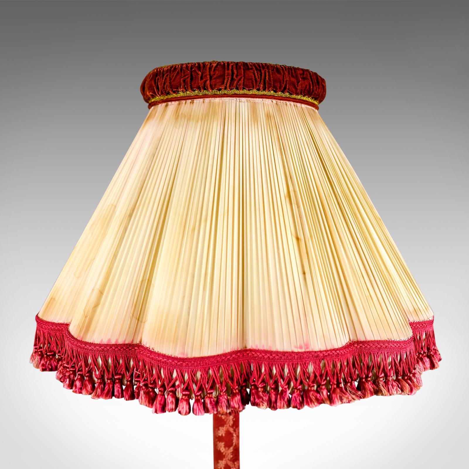 This is a standard lamp, a vintage Italian, fabric and gilt covered, floor standing light dating to the late Art Deco period, circa 1940. 

Classical overtones to the elegant stem 
Finished in a ruby silk cotton cloth with matching fringing
Bell