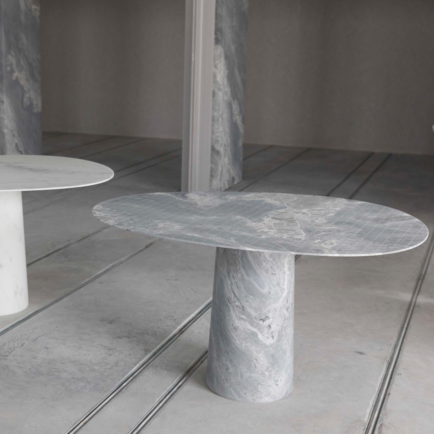 This majestic table fashioned of first-rate Versilys marble in its versatile gray variant has as primary goal to showcase the natural allure of the precious stone, its bright tone only interrupted by the delicate veinings that make it entirely
