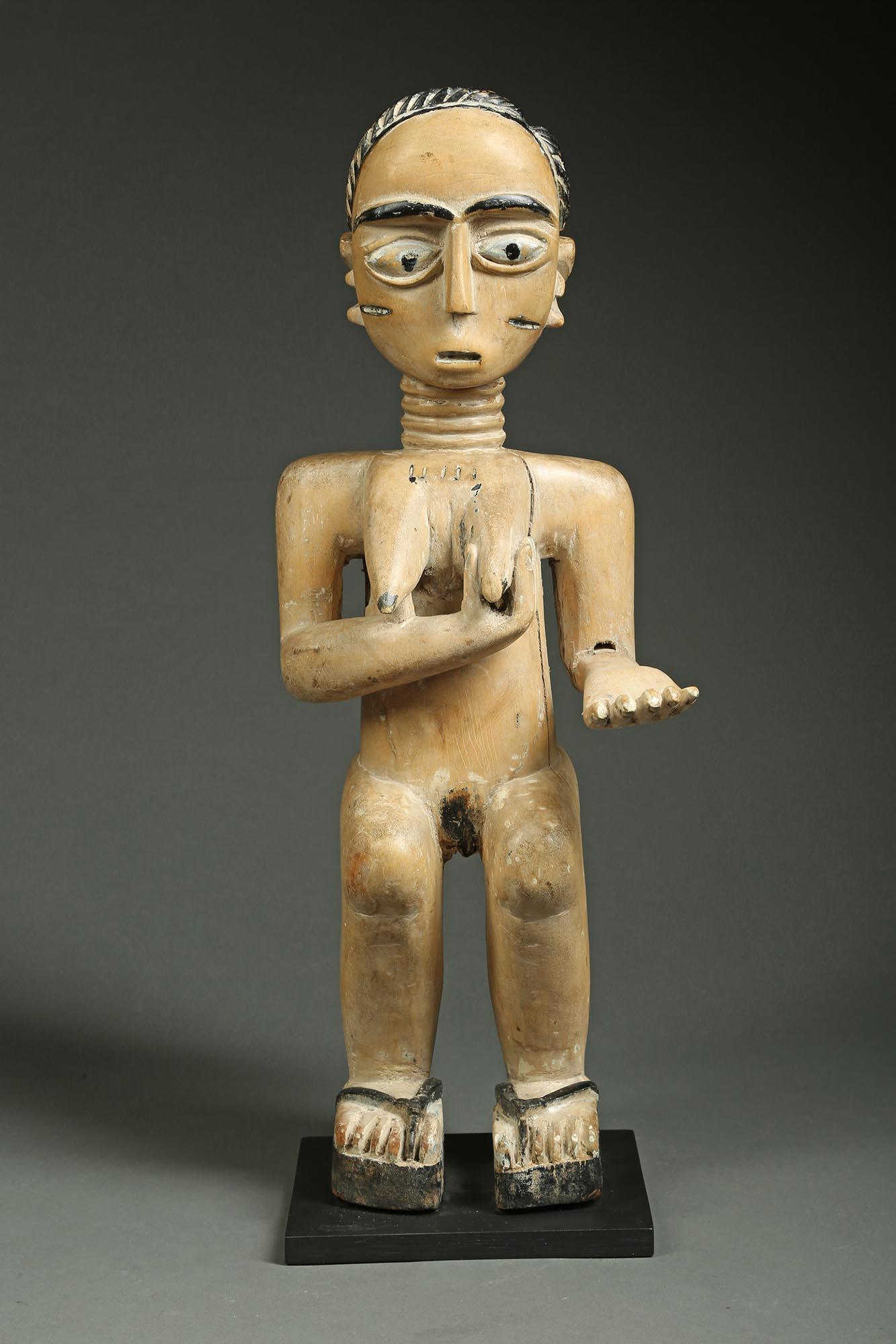 Standing Akan Ghana female figure, early 20th century, Africa.
Female figure with one hand on her breast, outstretched arm carved separately and still attached, original to the piece.
She has an expressive face with large open eyes and mouth, traces