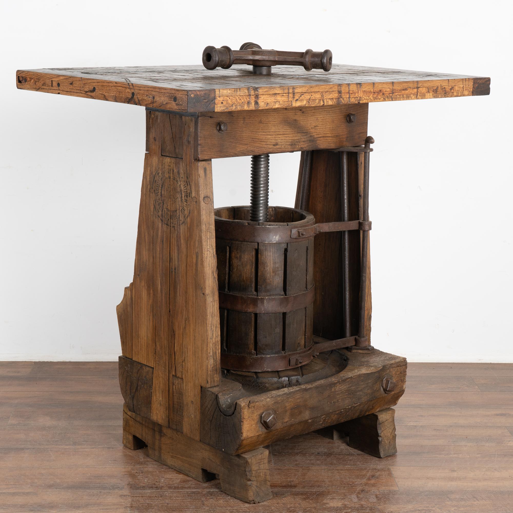 This unique wine tasting table or standing bar/table was created with an antique wine press from Hungary as the intriguing base.
The top is made from old boxcar/railroad car flooring which lends a strong balance to the industrial feel of the lower