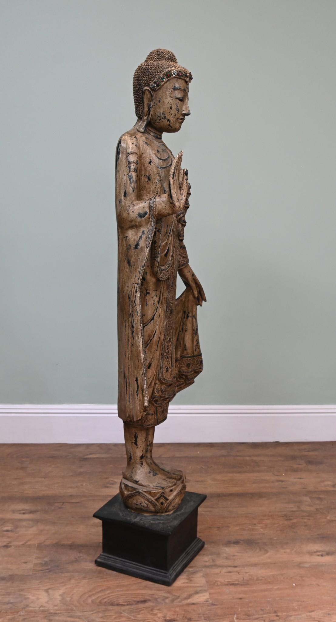 Impresionante Buda birmano de pie tallado en madera con un acabado de pintura dorada sobrelavada que le da un acabado decorativo
Esto añadirá serenidad y calma a cualquier interior
La cinta de la cabeza está adornada e incrustada con piedras verdes