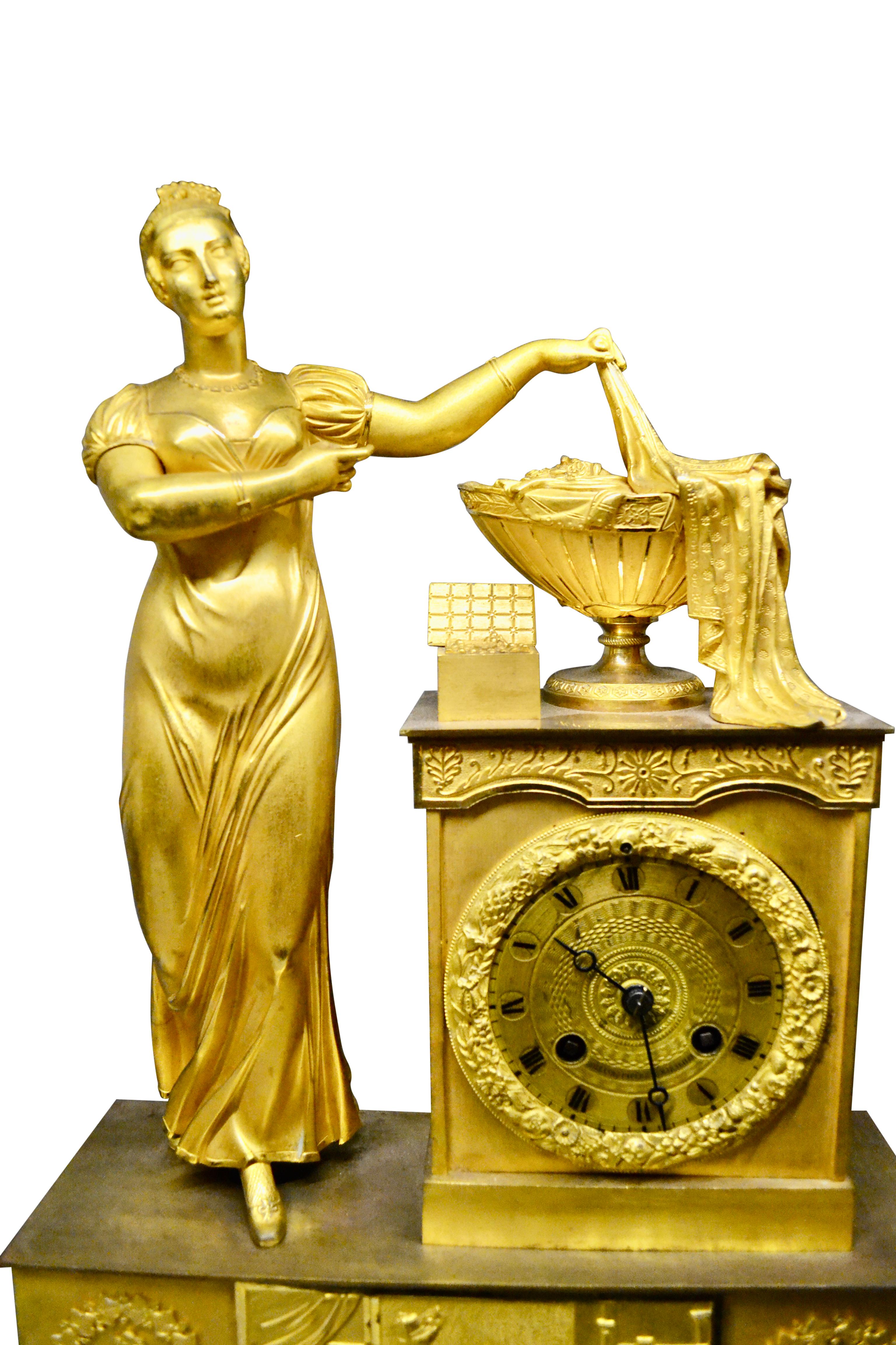 Français Bronze doré Empire  Pendule représentant une dame classique debout dévoilant une urne d'abondance en vente