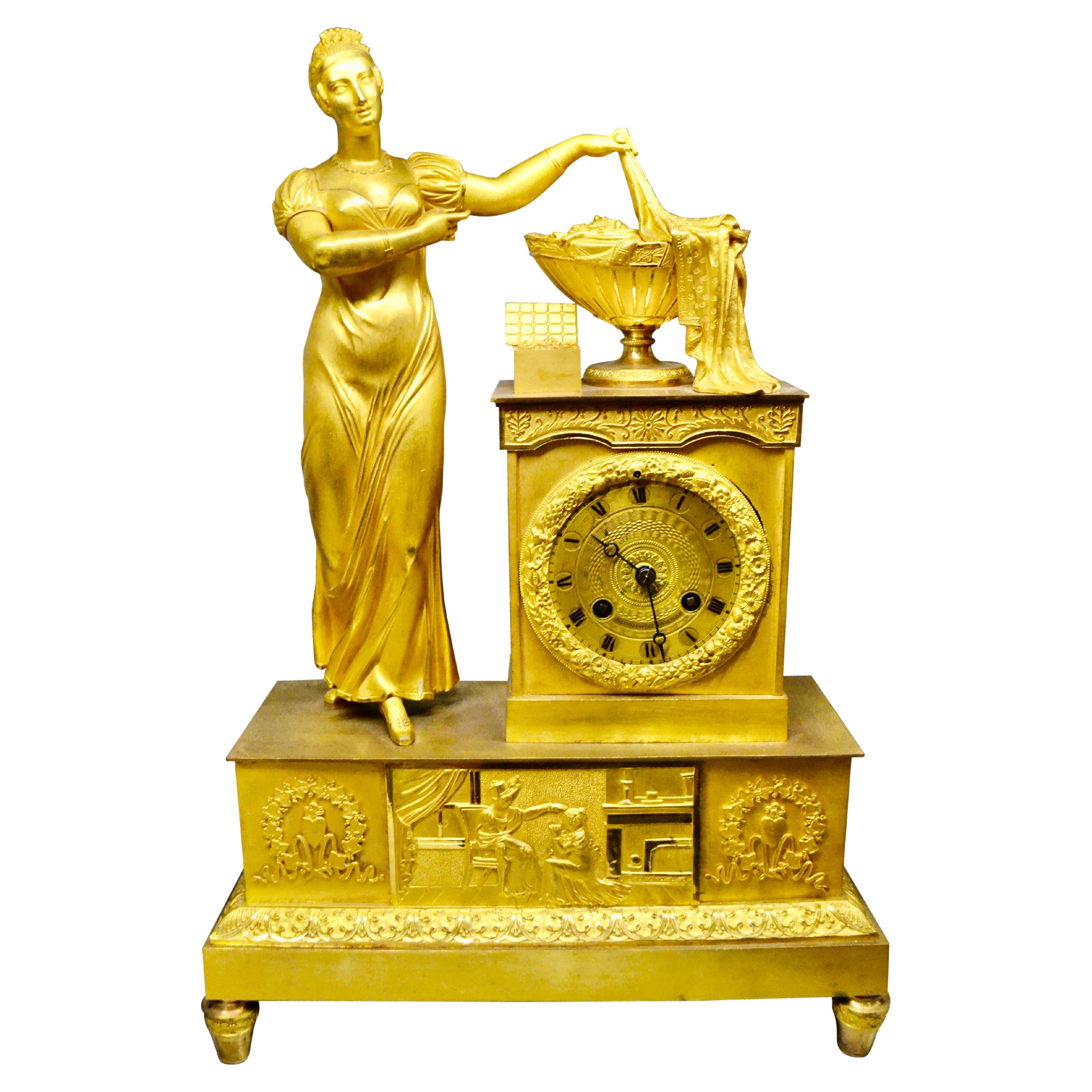 Empire Gilt Bronze  Clock of Standing Classical Lady Unveiling an Urn of Plenty For Sale