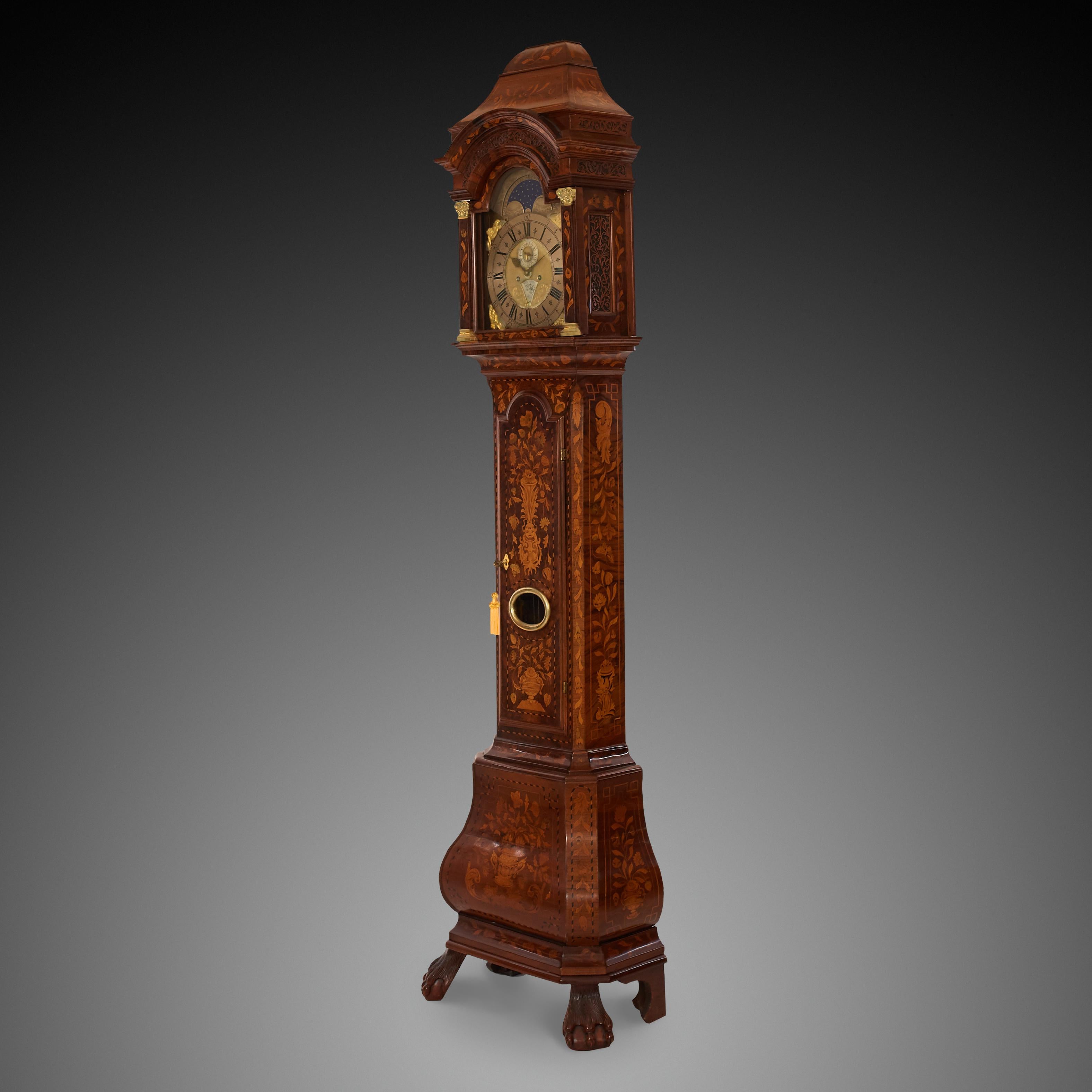 Uhr aus dem 18. Jahrhundert in Nussbaumfarbe und holländischem Stil. Eine Uhr mit einem Sockel auf den Beinen mit floralen, botanischen Ornamenten verziert. Ein Schild mit den Phasen des Mondes in Form eines Bogens
Es gibt Funktionen wie Sekunden,