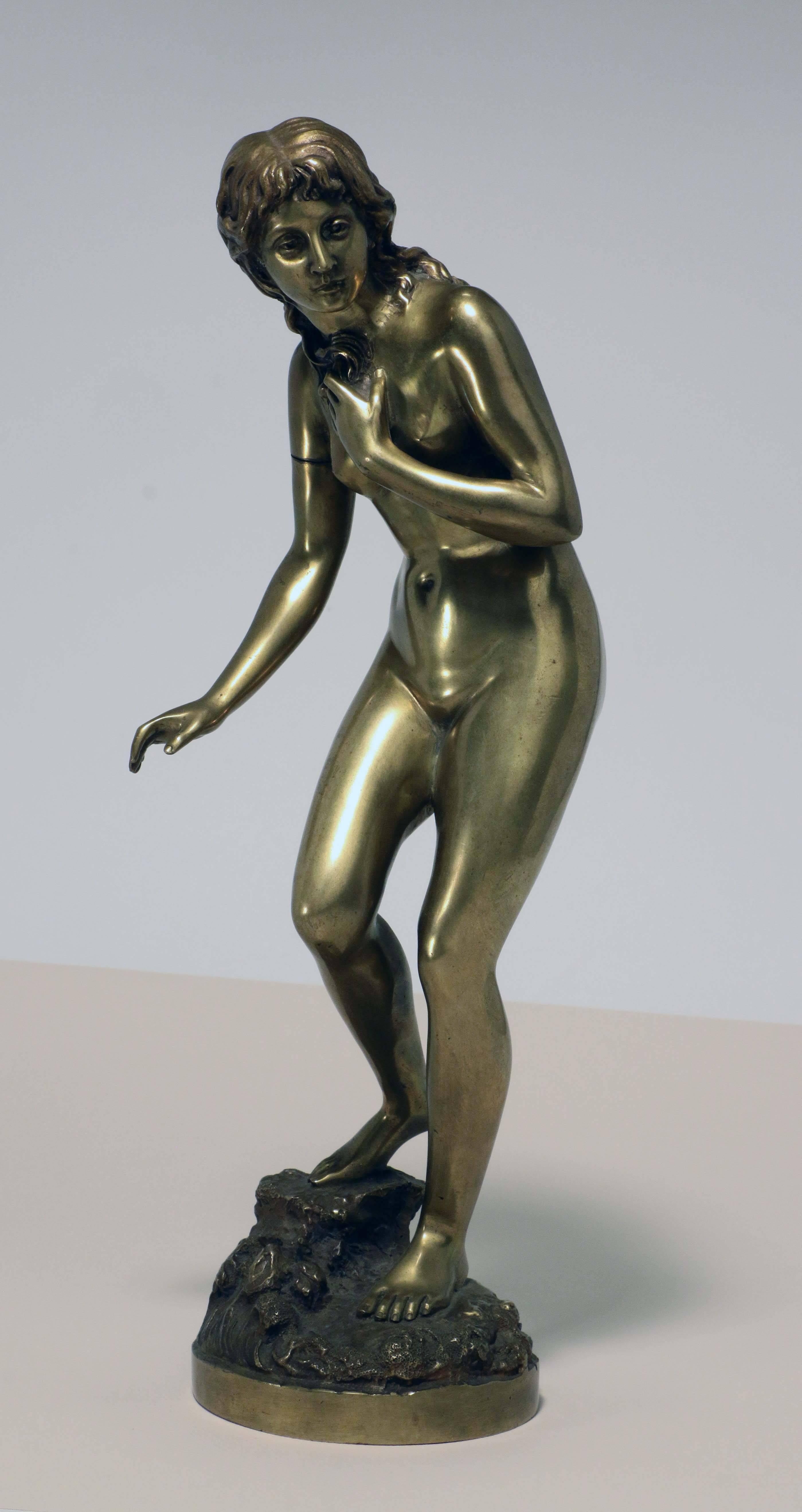 This bronze figure of a nude maiden dates from the early 20th century. She crouches slightly as she enters the water, one foot on a rocky outcrop, with stylized waves at her feet. According to Berman this artist flourished at the turn of the century.