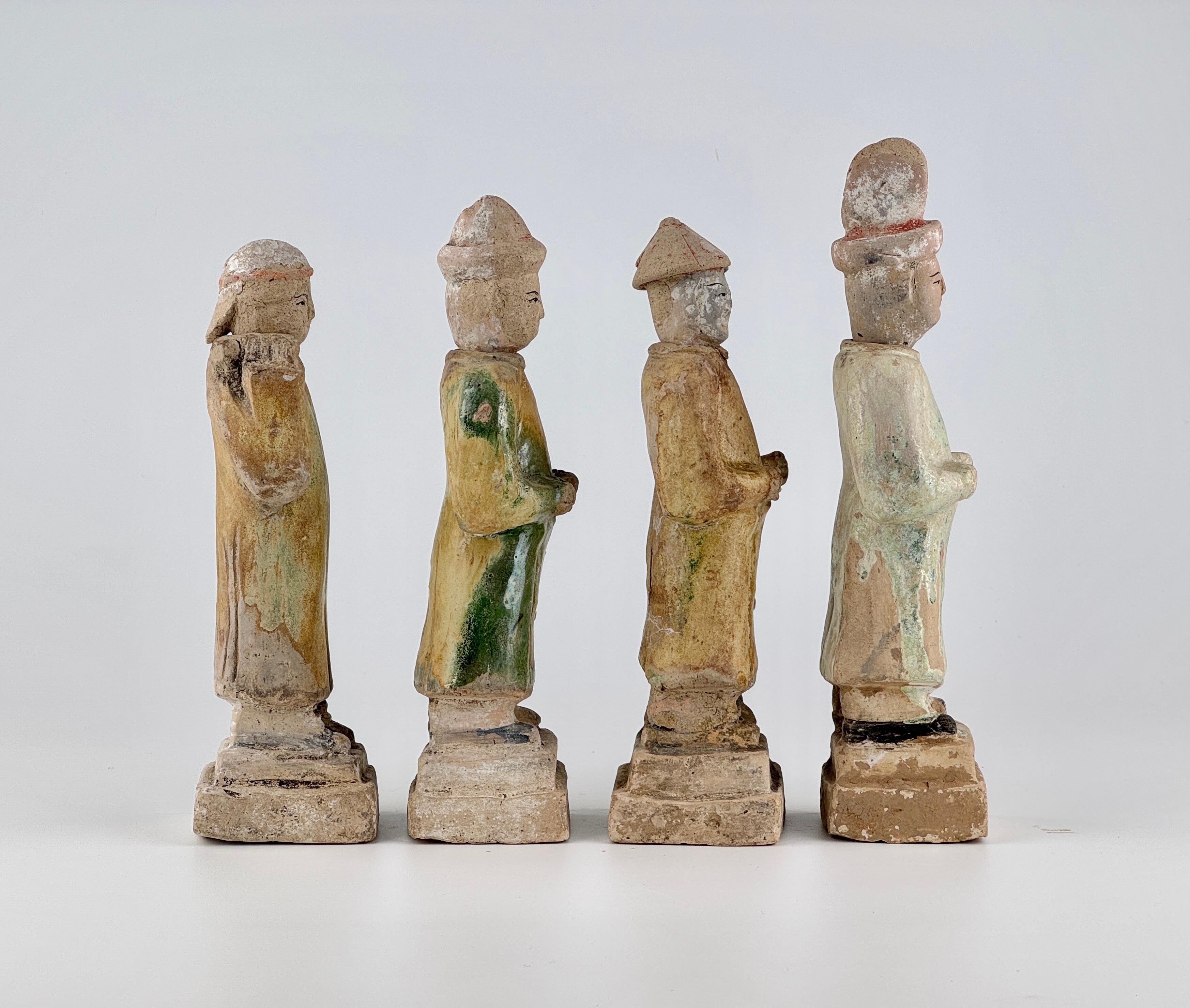 The first figure wears a short cap and takes a posture as if carrying something on the shoulder, possibly symbolizing a servant or a messenger.
The second figure wears a tall hat and clasps both hands together in front, likely representing an