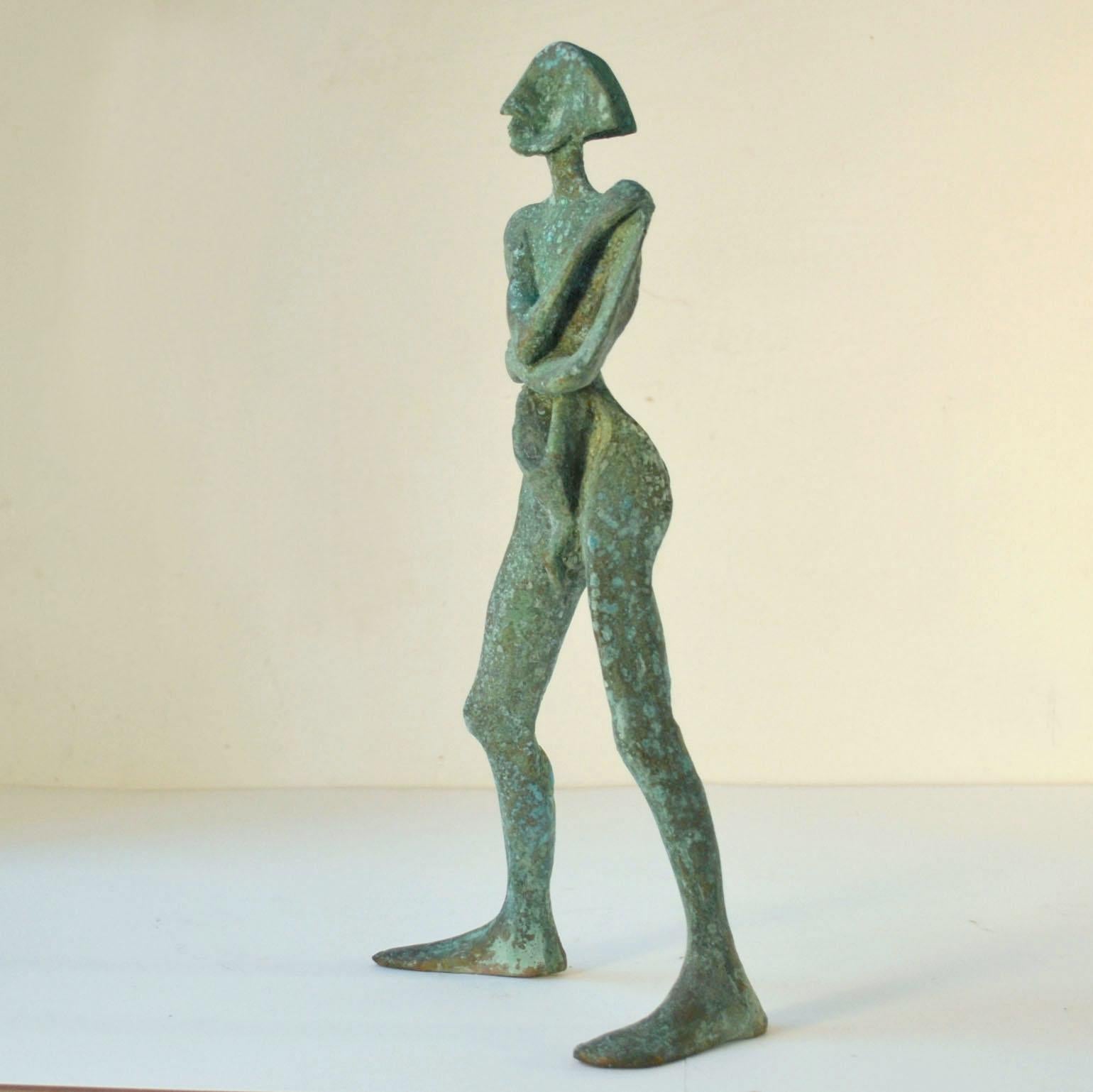 Standing man is an abstract sculpture in bronze titled 'Compass' with a green patina by the Dutch sculptor Lies Gronheid, 1982. His profile is divided into in four directions like a compass with his legs position apart and arms crossed. 
We use a