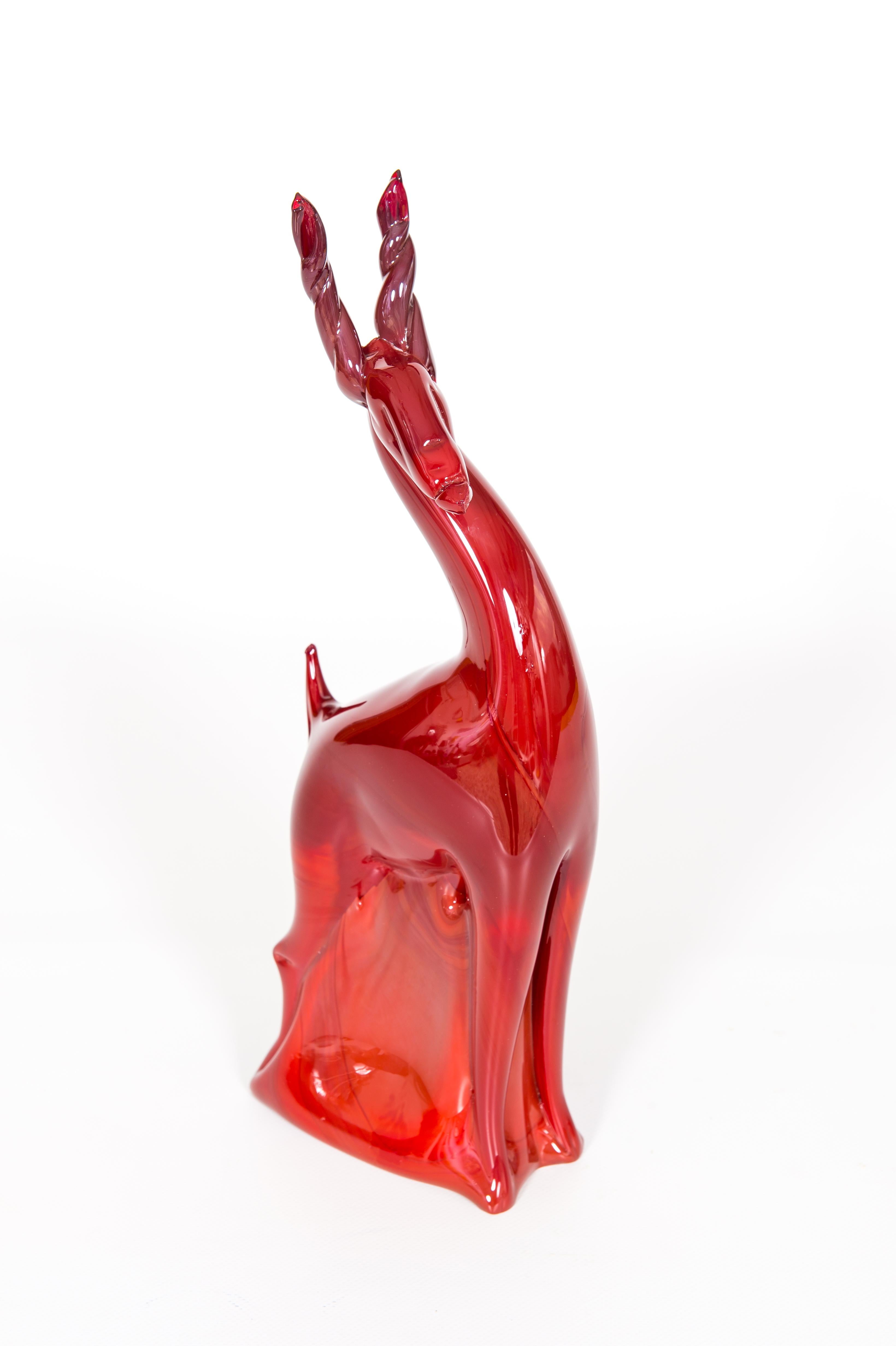 Stehender Rubinroter Hirsch aus mundgeblasenem Murano-Glas mit roten Schattierungen Venedig Italien 1990er Jahre.
Diese in den 1990er Jahren in Murano, der für ihre jahrhundertealte Glasmachertradition bekannten venezianischen Insel, vollständig