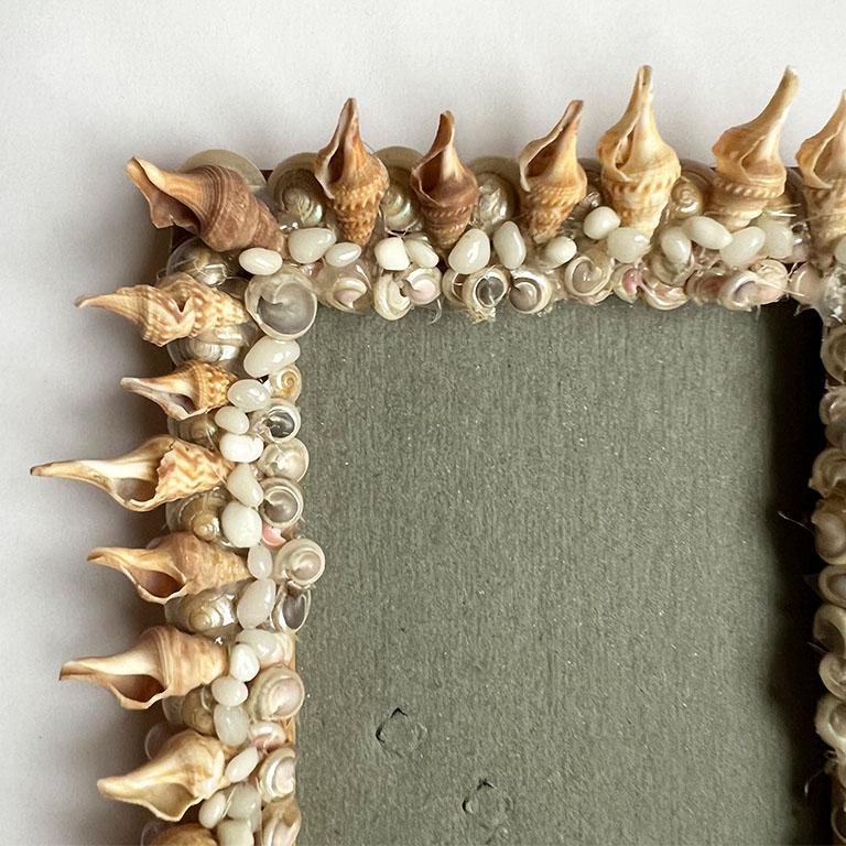 A beautiful standing sea shell encrusted photo frame. This frame holds a 4