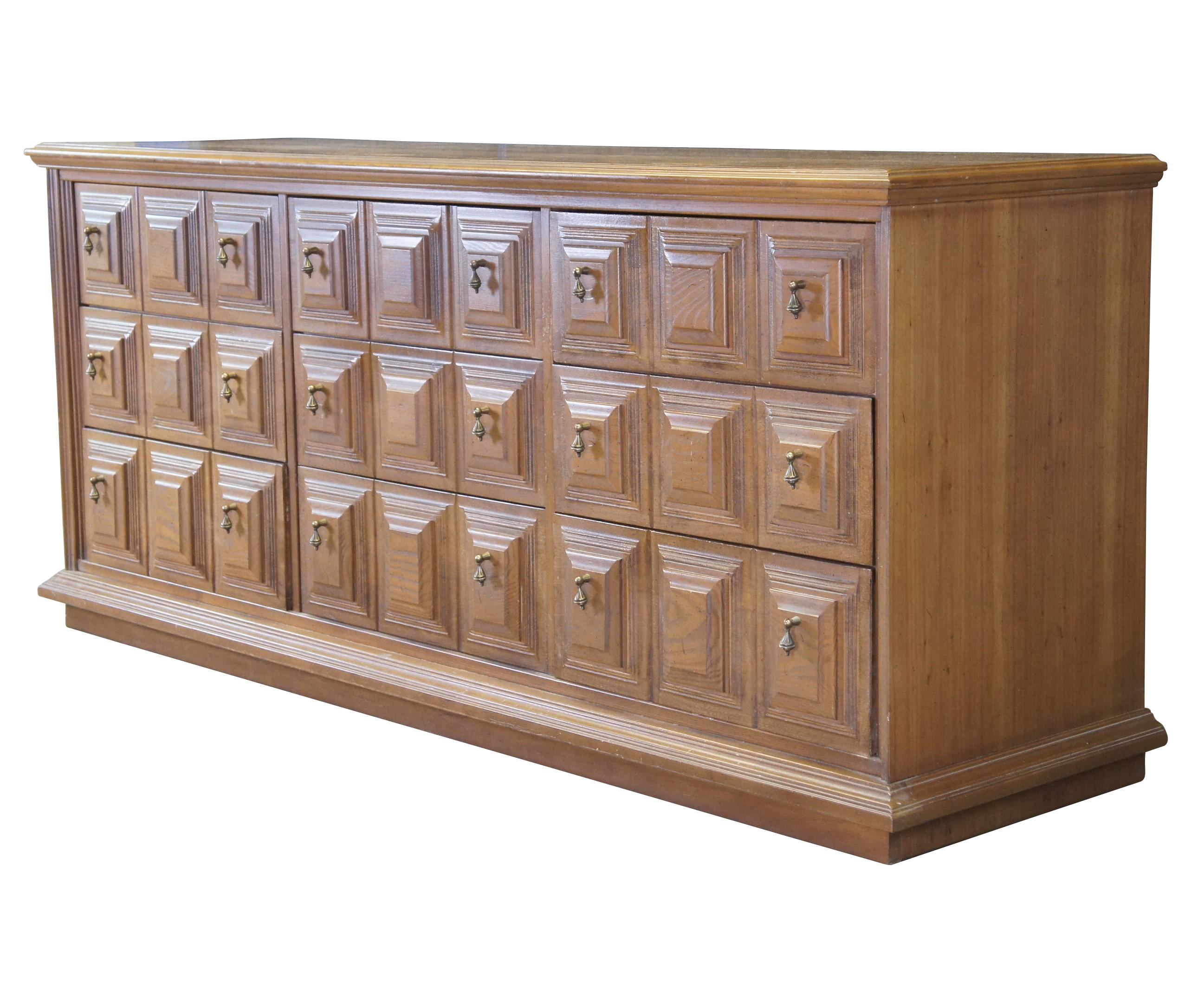 Stanley Furniture mid century paneled oak nine drawer dresser. Features a blend of Italian Provincial and Brutalist styling. The long rectangular case has nine dovetailed drawers with raised square paneling and brass knocker drawer pulls. Great for