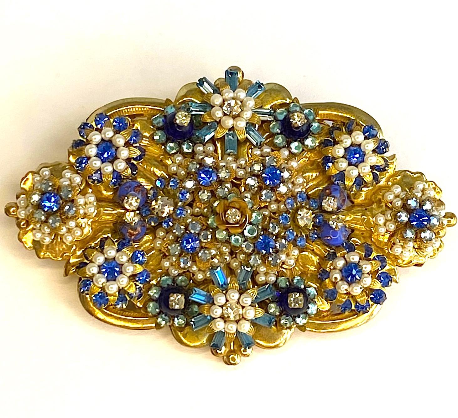 A stunning example of the artistry of designer Stanley Hagler. Small faux seed pearl beads, aqua and royal blue rhinestones, navy blue beads and clear rhinestones are carefully wired in a floral pattern onto a horizontal plate. This plate is pierced