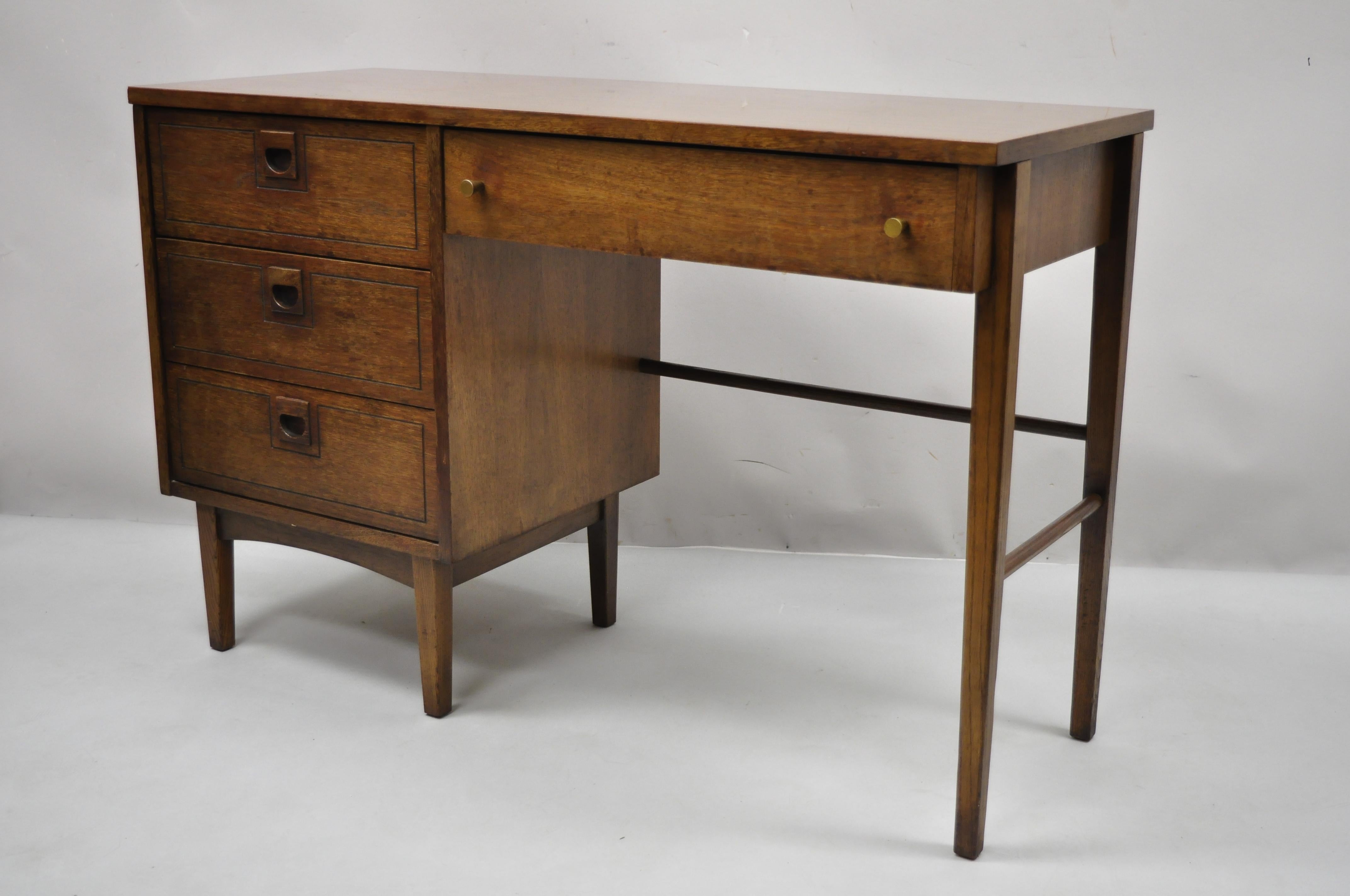 Stanley Mid-Century Modern walnut and Formica writing kneehole work desk. Item features wood grain formica top, sculpted wood and brass pulls, beautiful wood grain, 4 drawers, clean modernist lines, quality craftsmanship. Circa Mid 20th Century.