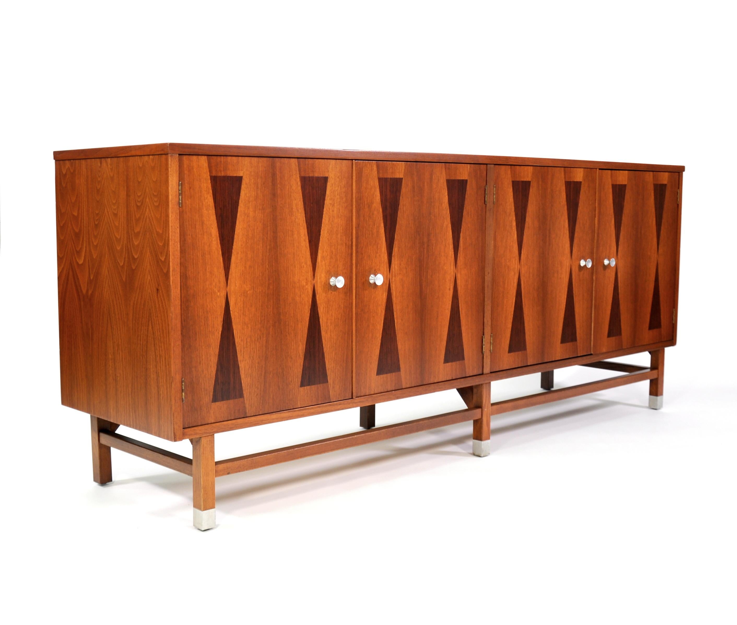 Gorgeous Mid-Century Modern bar cabinet from Stanley's Linear Precision Group, circa mid-1960s. The vintage sideboard features a top with rosewood banding and four doors with hourglass rosewood marquetry inlaid fronts, opening to an interior fitted