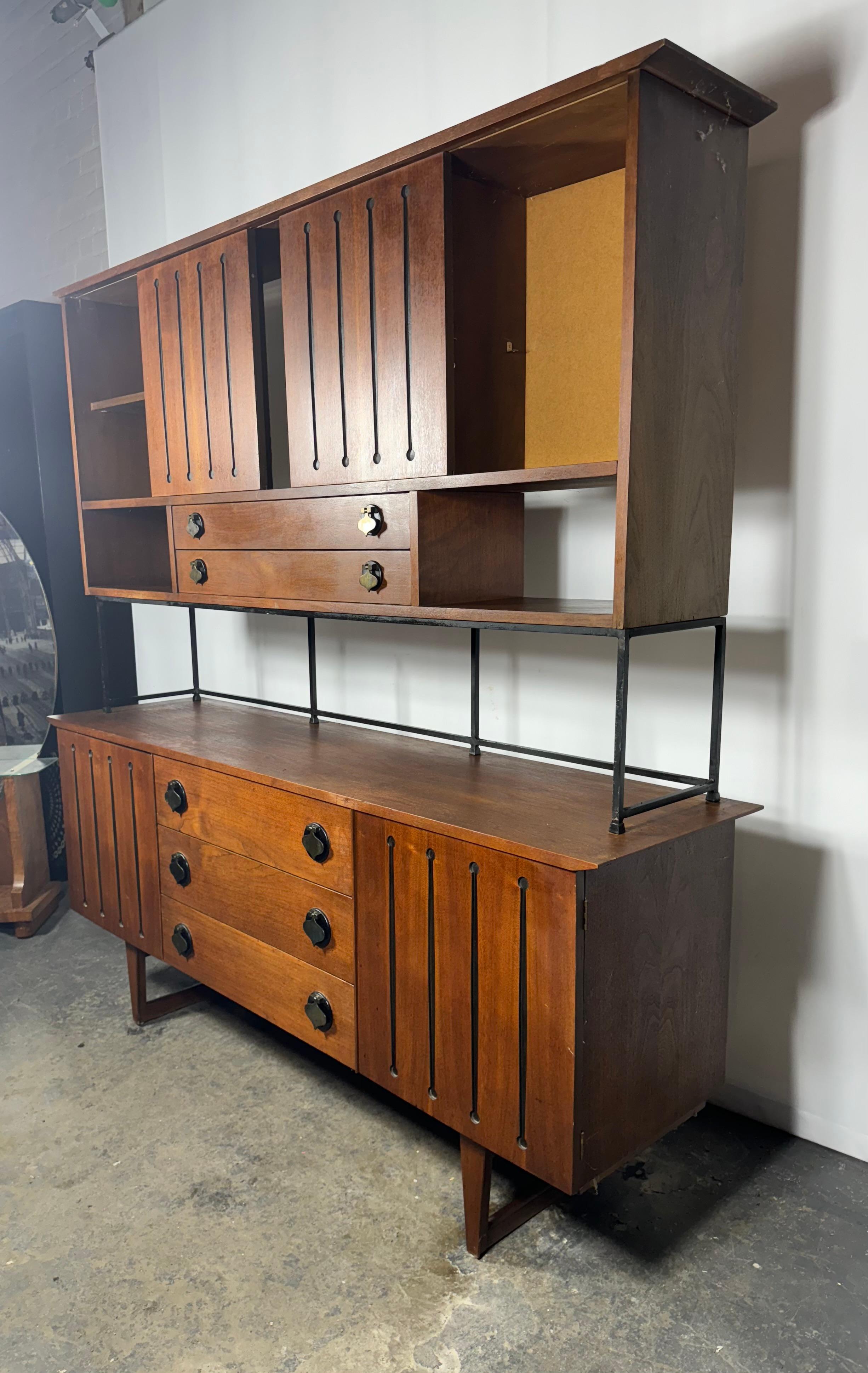Epique et rare crédence / meuble mural / meuble de bar à deux niveaux de la Collection S pour Stanley Distinctive Furniture vers les années 1960. Fabriquées en noyer avec des détails ébonisés, les tirettes à bêche apportent une inspiration marocaine