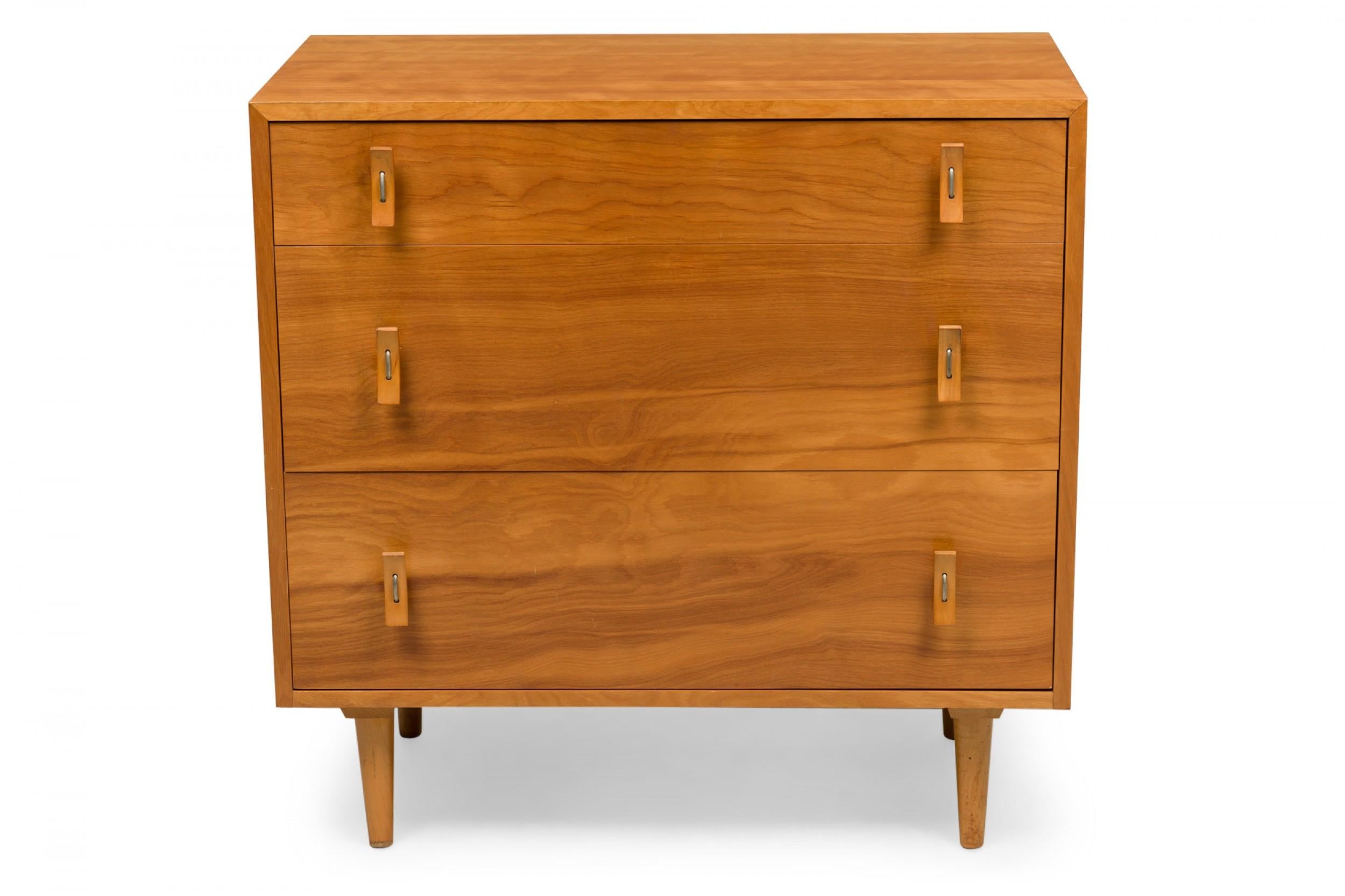 American mid-century blonde wood three drawer chest with curved plywood drawer pulls resting on four tapered dowel legs. (STANLEY YOUNG FOR GLENN OF CALIFORNIA)