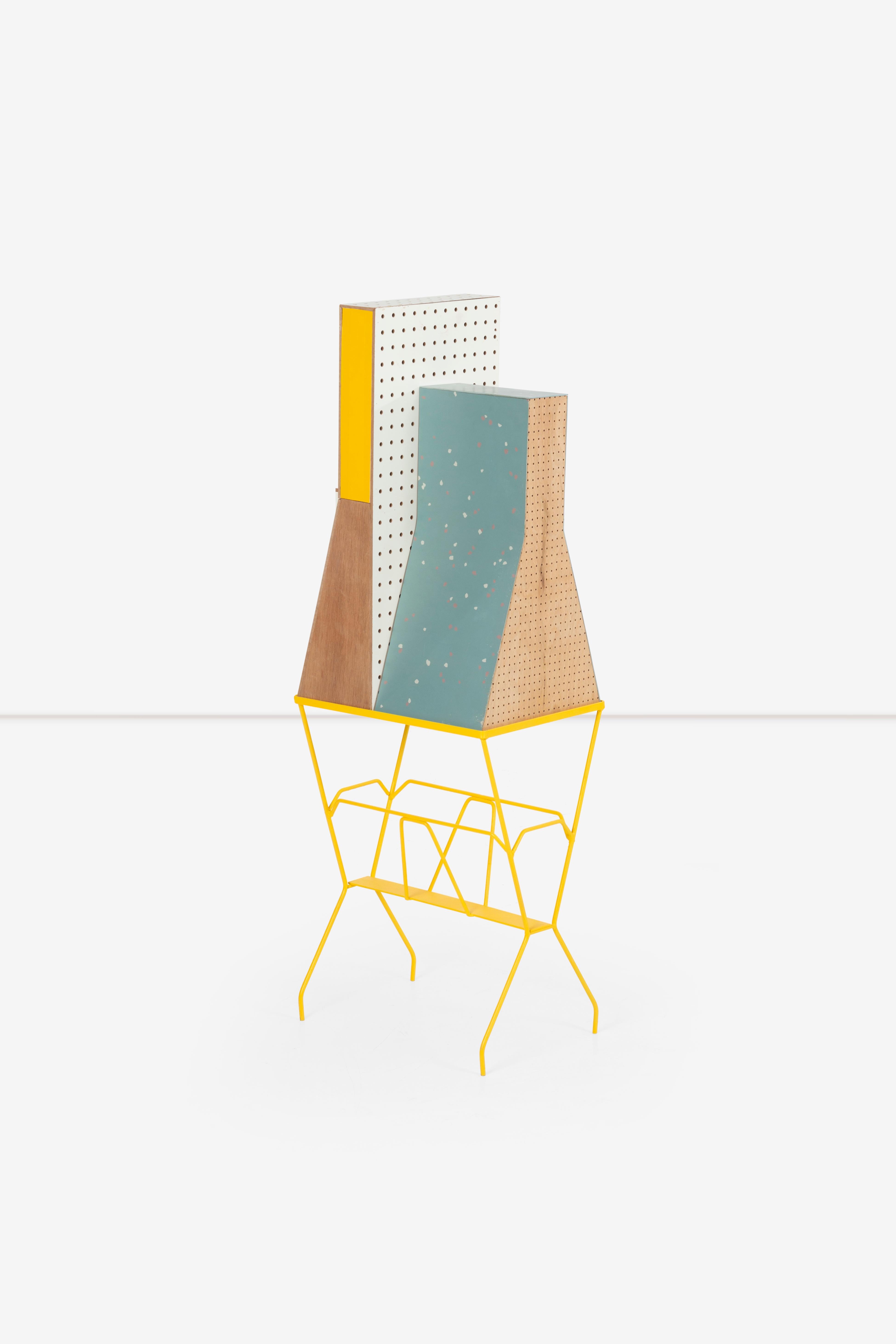 Teague esplora questa intuitiva strofa 1, come una giocosa 
tra i modelli di architettura e la scultura utilitaria.
Realizzato con un comodino trovato e acquistato in ferro e pezzi vari 
dal suo negozio.  