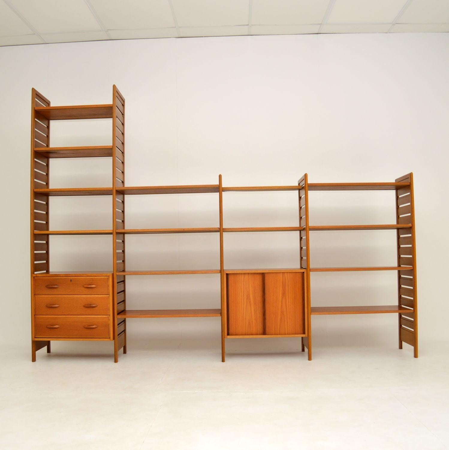 A large and impressive teak Ladderax shelving system by Staples. This was made in England and dates from the 1960’s.

This four bay system consists of two tall ladder rails, three shorter ladder rails, a three drawer chest, a sliding door cabinet