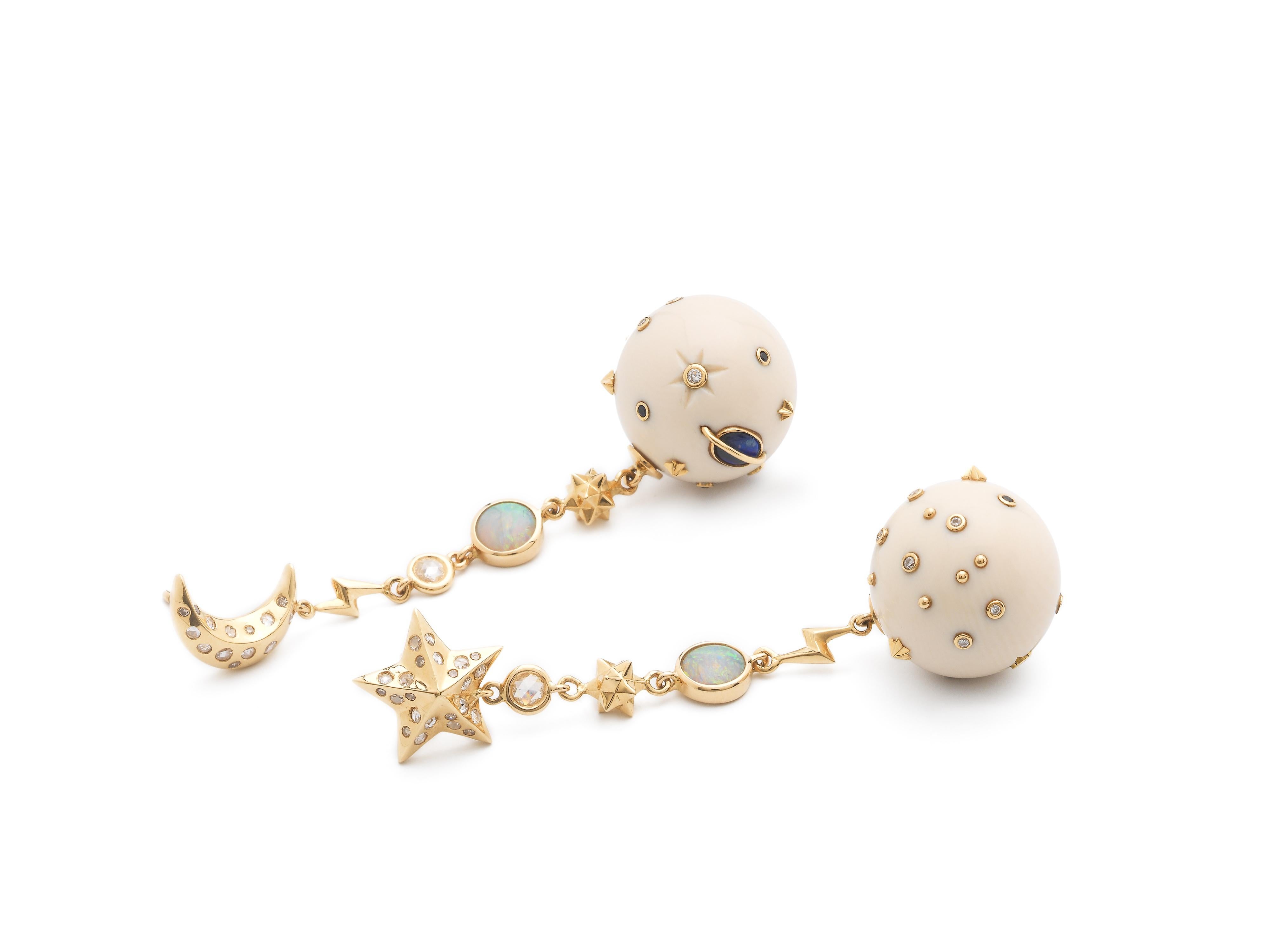 Carved in 60,000-year-old mammoth tusk – which is surprisingly light to wear – the Star and Moon Mammoth Galaxy Earrings are designed as two mammoth orbs set with white diamonds, blue sapphires, opals, and 18k yellow gold accents. The drop earrings
