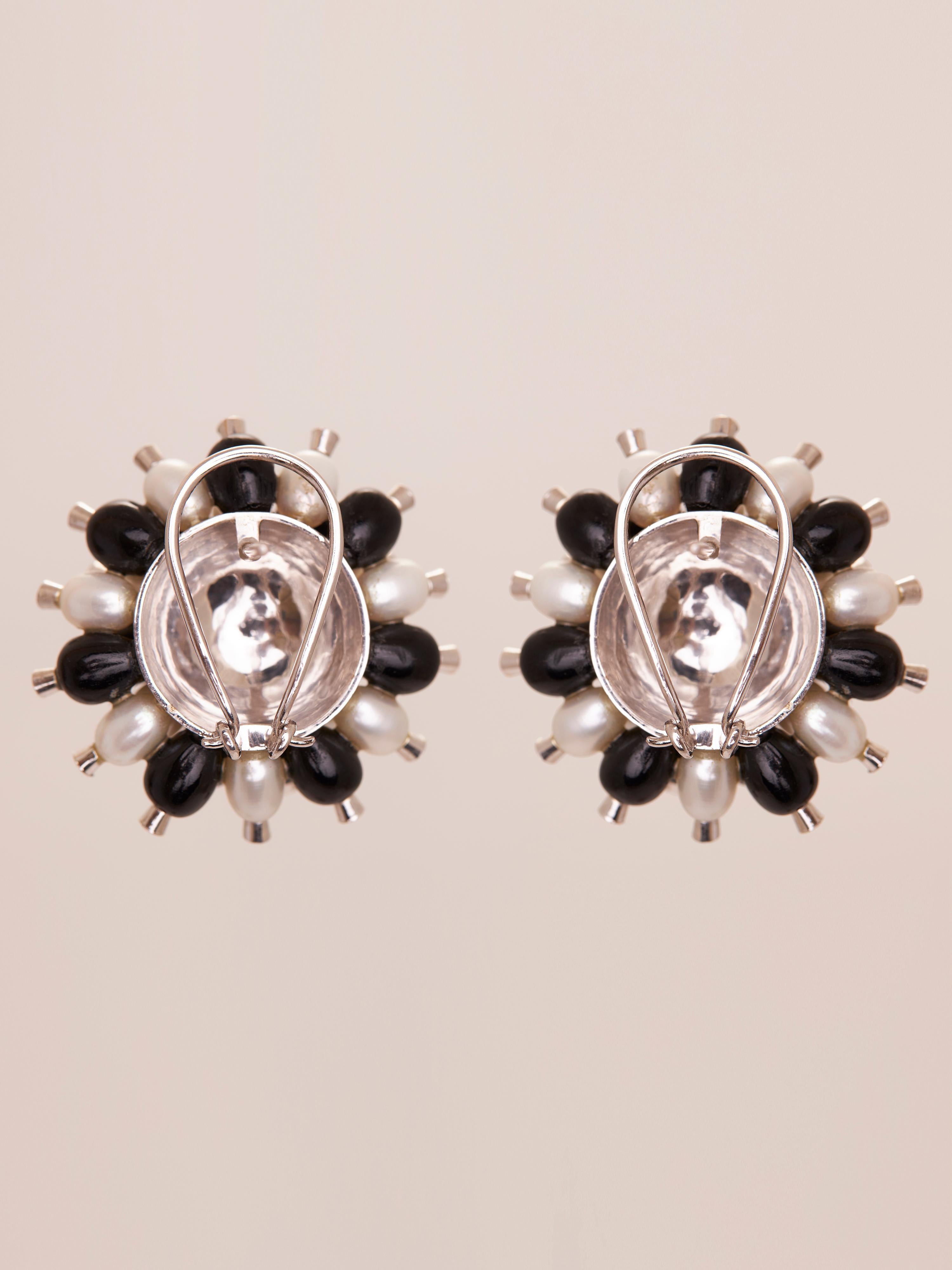 Gli orecchini Star Burst con perle e onice nero combinano la luminosa tranquillità delle perle con la forza di fondo dell'onice nero. Questi orecchini creano una sinfonia celestiale, perfetta per chi cerca un equilibrio tra luce e oscurità.