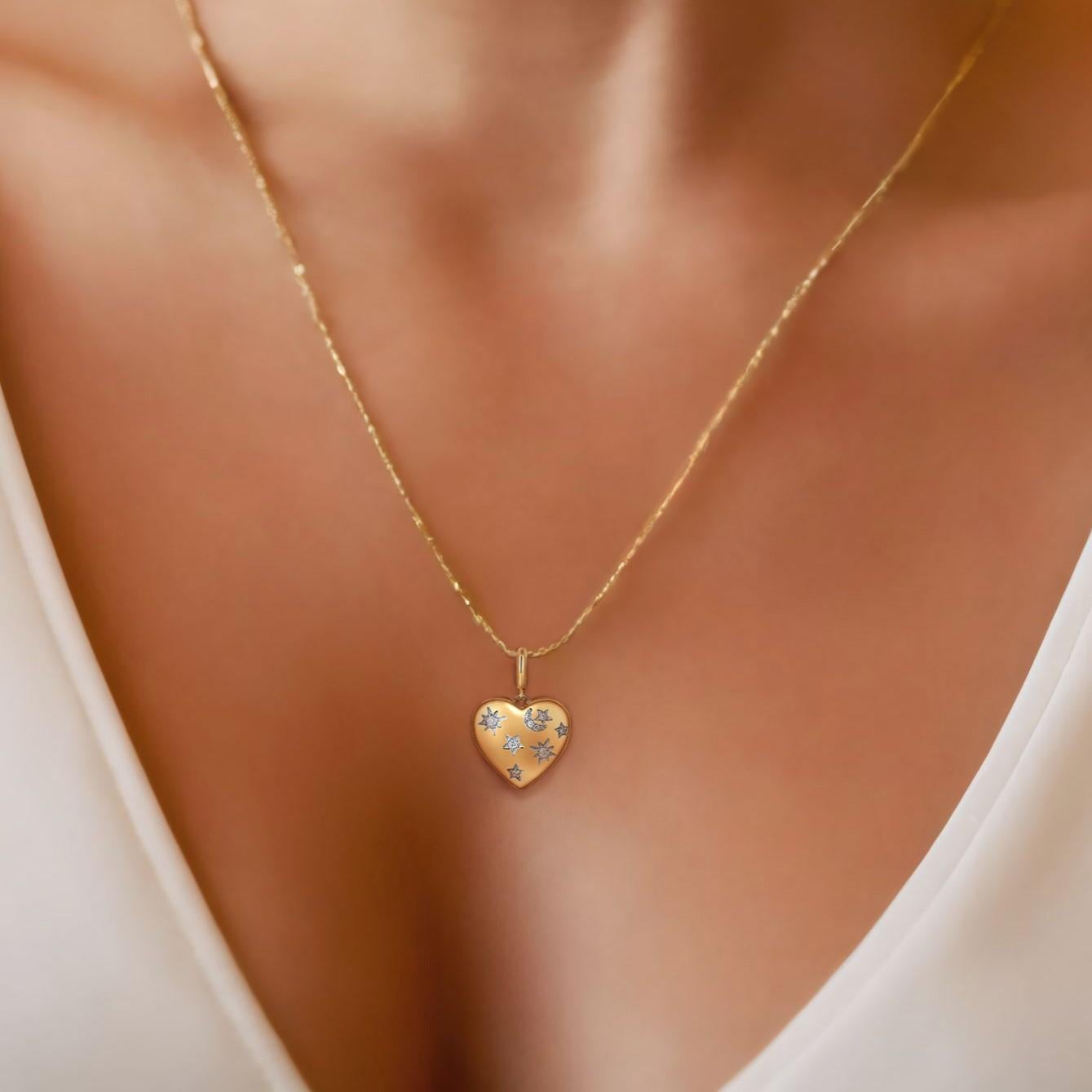 Questo incantevole ciondolo presenta una delicata forma a cuore ornata da un accattivante motivo a stella e luna. Realizzato in oro giallo 14K, il ciondolo sfoggia diamanti a taglio pieno che aggiungono un tocco scintillante al design celeste.
