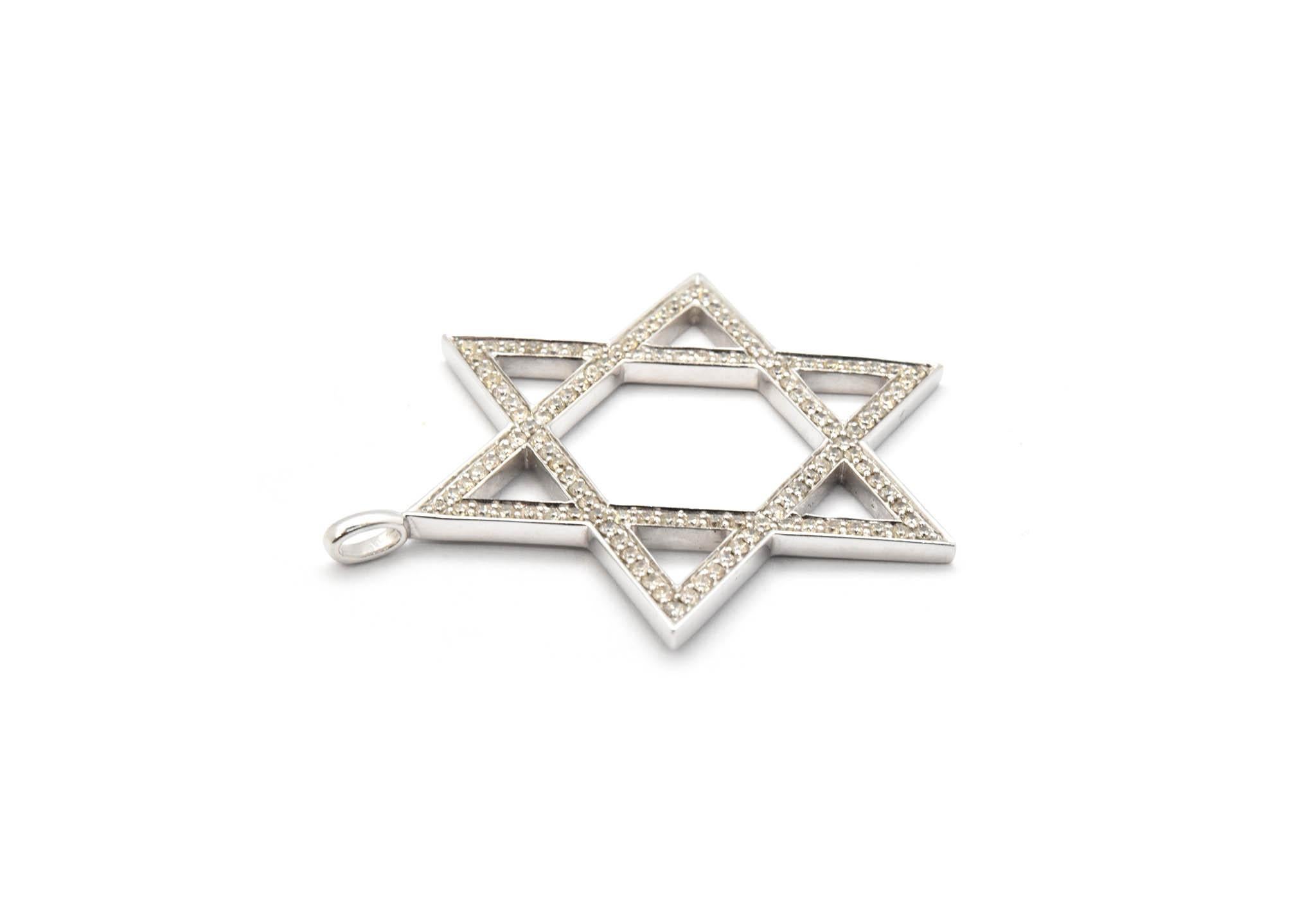 This is a Star of David pendant crafted in fine 14k white gold and pave set with round diamonds. The diamonds weigh 1.25 carats. The pendant measures 43.68mm in diameter. There is a bail to mount the pendant on a chain. The pendant weighs 3.70 grams.