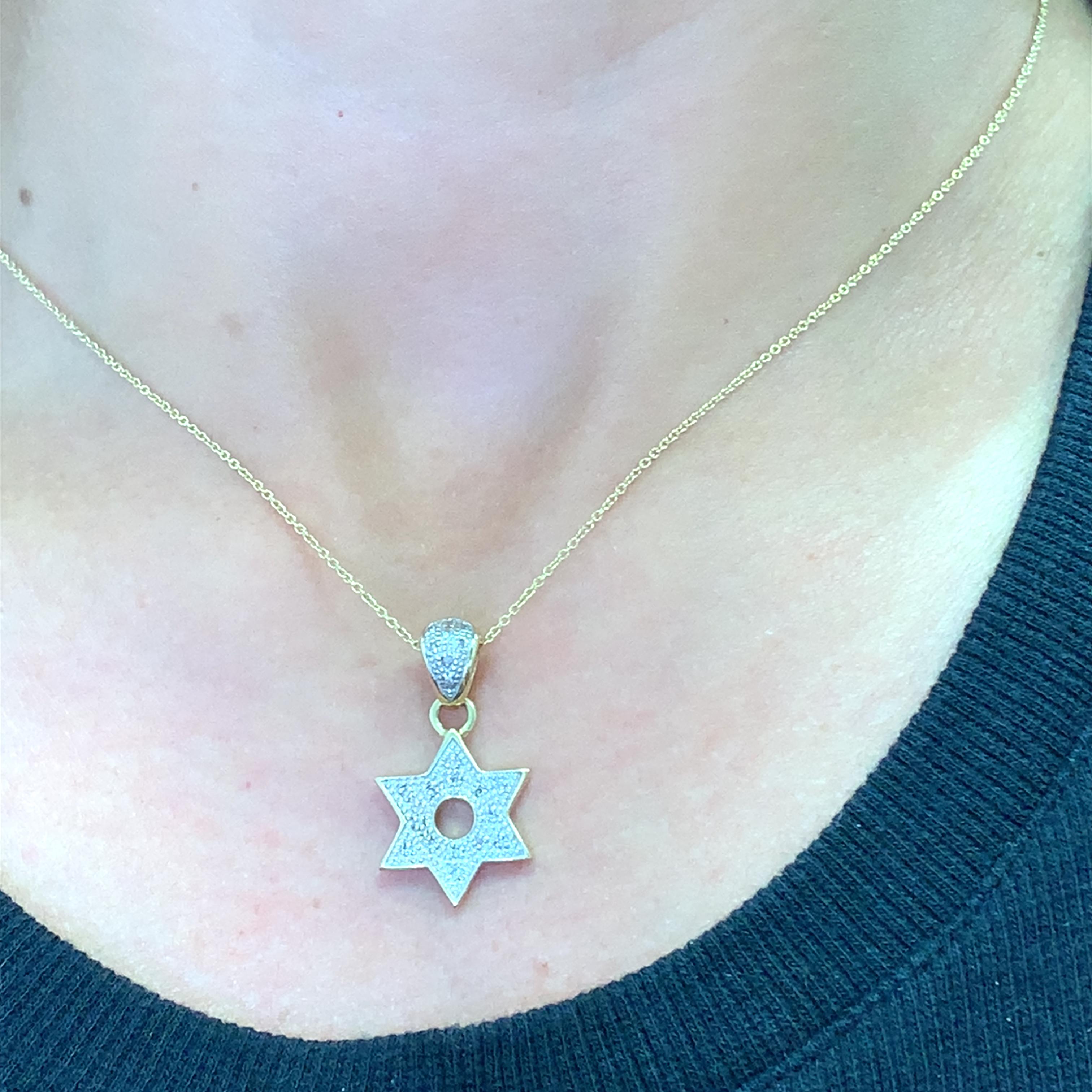 Adorn your neckline with this radiant yellow gold pendant. The star of David design is pave-set with round brilliant cut diamonds, offering a dazzling sparkle. This piece combines faith and fashion, perfect for adding a touch of elegance to any