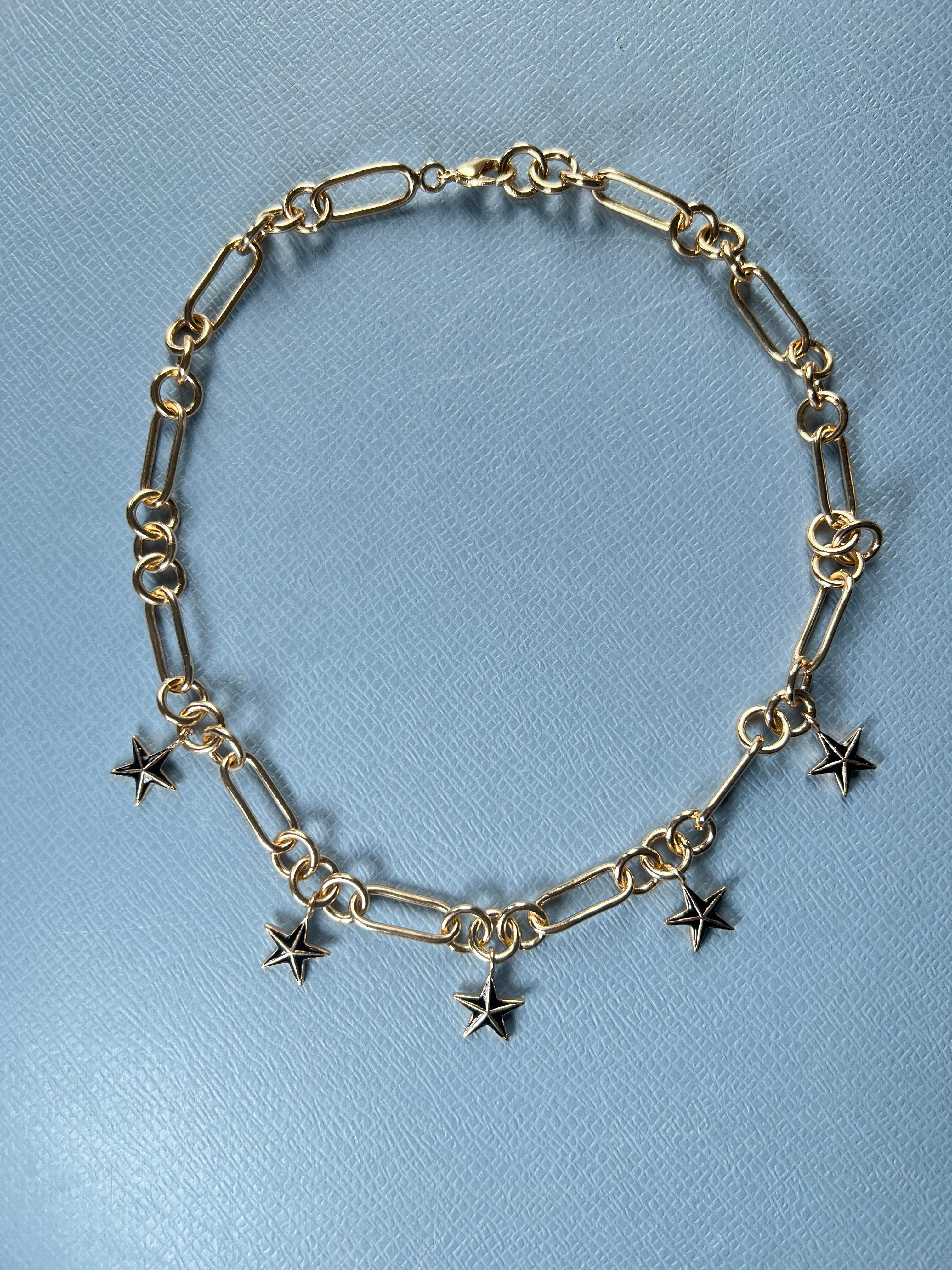 5 Star Pendant Chunky Choker Chain Necklace in 14k Gold Plate with Black hand painted Enamel on each star

The five-pointed star, often known as the pentagram, holds significant spiritual symbolism across various traditions and beliefs. It typically