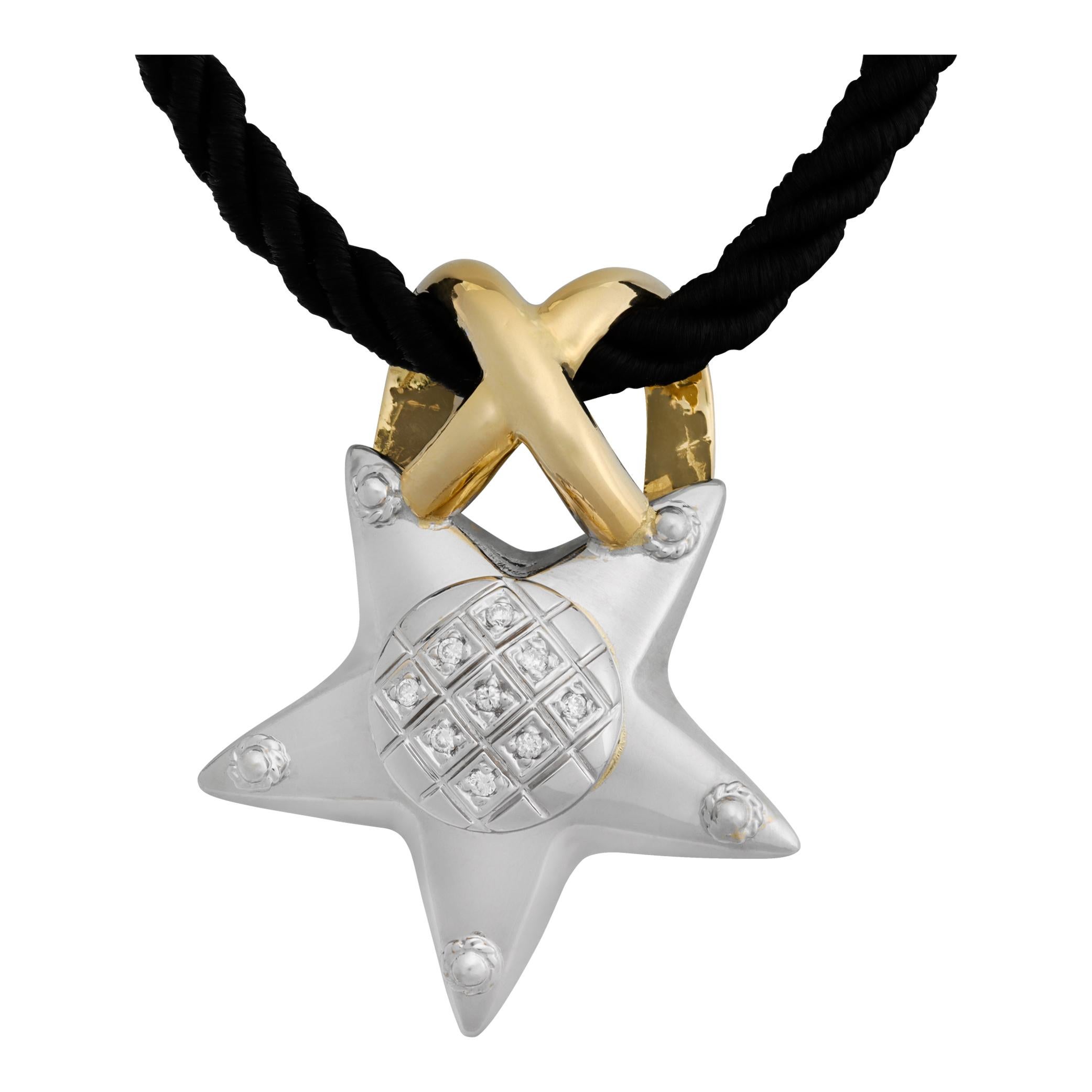 Ciondolo a stella in oro bianco e giallo 18 carati con diamanti su un cordoncino di seta impanato nero. I diamanti rotondi taglio brillante hanno un peso totale di circa 0,072 carati, sono bianchi e puliti.  Il Corde è regolabile a seconda della