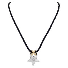 Colgante estrella con diamantes en un cordón de seda empanado negro