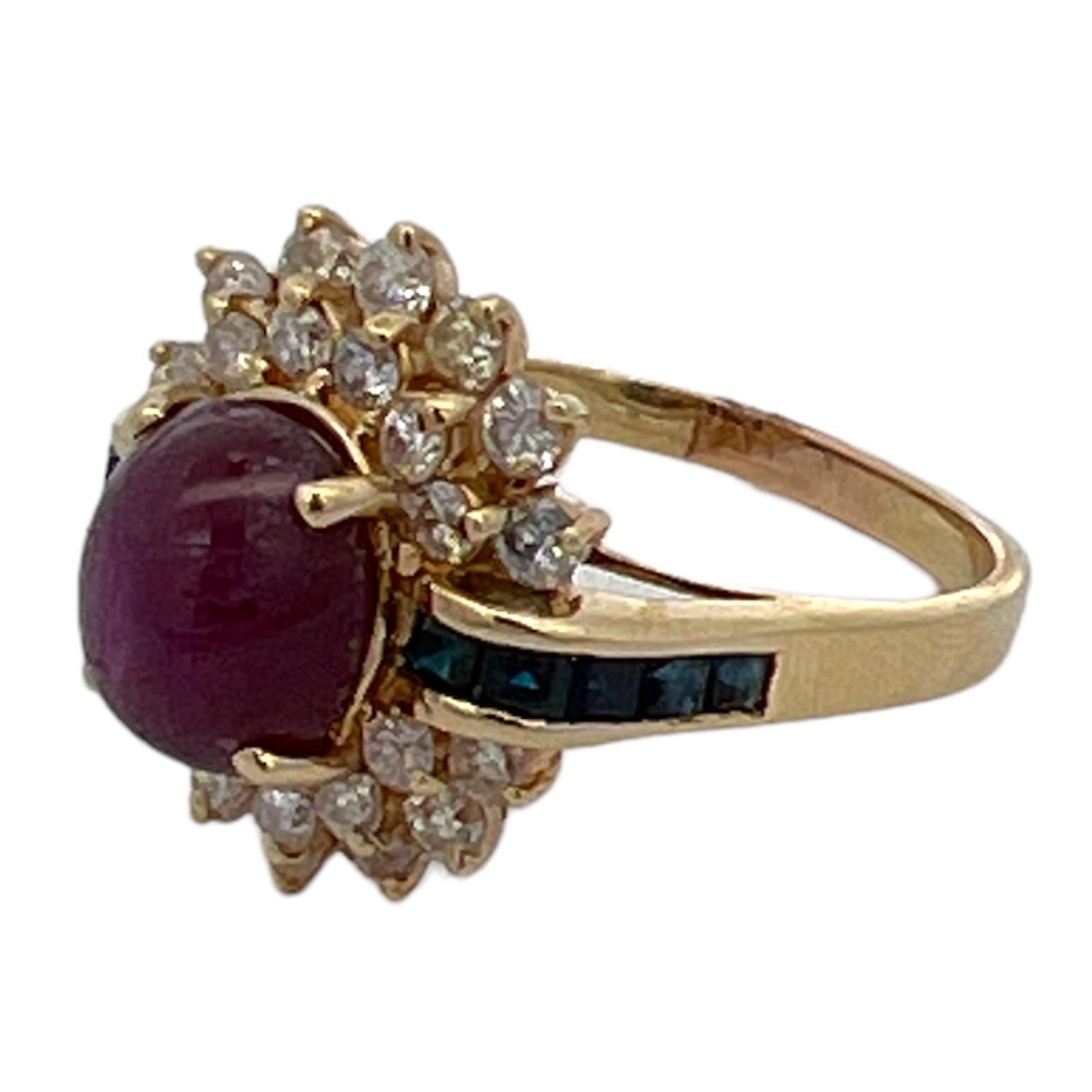 Star ruby diamond sapphire vintage cocktail ring crafted in 14 karat yellow gold. The ring features an approximately 3.00 carat star ruby gemstone, 26 round brilliant cut diamonds weighing approximately 1.00 CTW, and sapphire accents. The diamonds