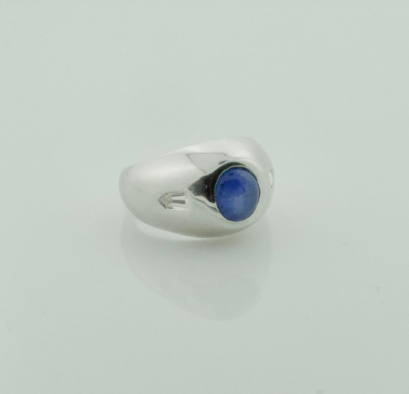 Star Sapphire and Diamond Pinky Ring in Platinum Circa 1940's
A Delightful Classic 
One Cabochon Star Sapphire Weighing 3.00 Carats Approximately [ A Vibrant Blue With a Nice Star That is Hard To Capture in Photos]
Two Bullet Cut Diamonds Weighing