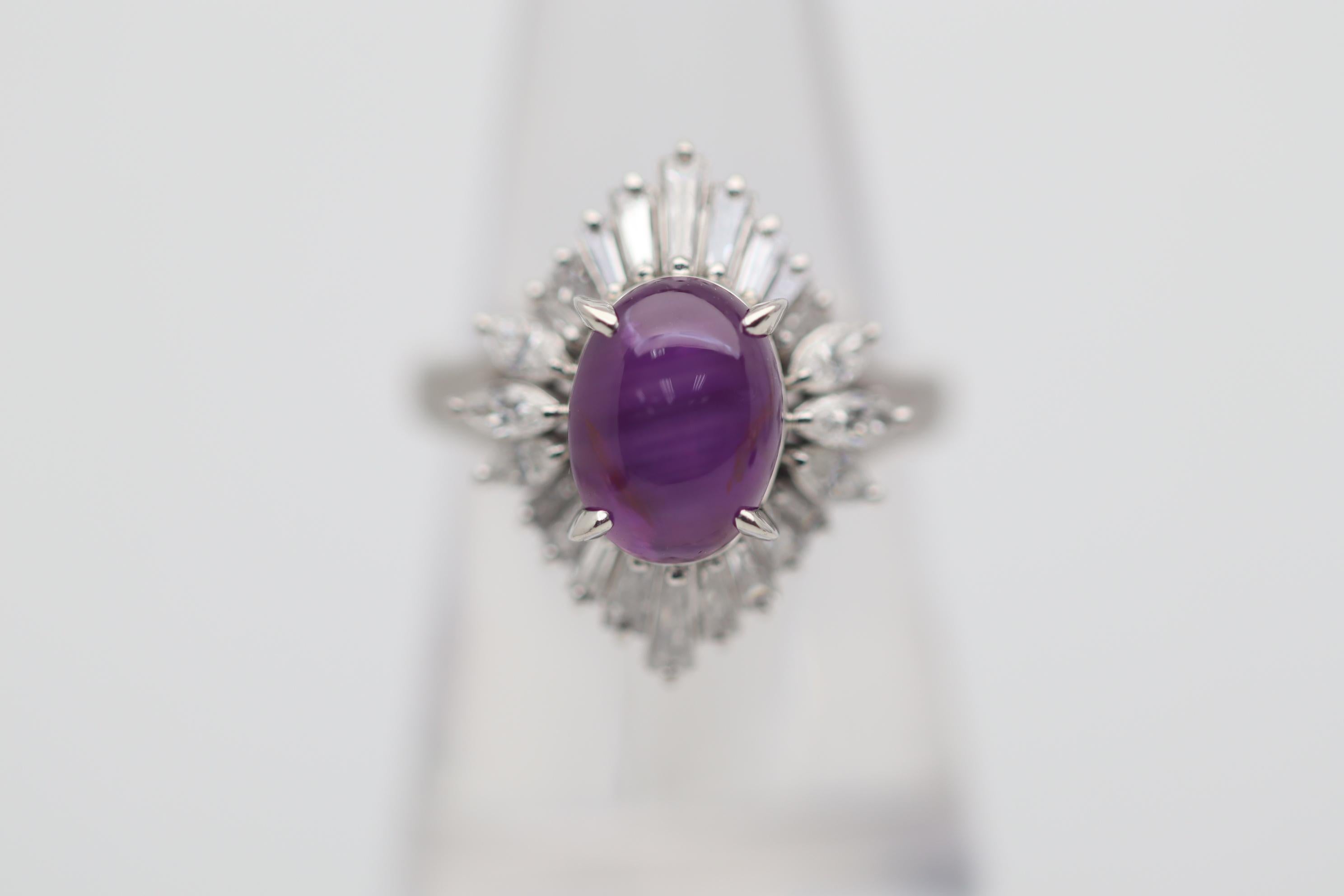 A lovely strongly colored star sapphire takes center stage! It weighs 4.70 carats while having a rich intense reddish-purple color. Adding to that the sapphire has a strong 6-rayed star with each ray being sharp and full. It is complemented by 1.15