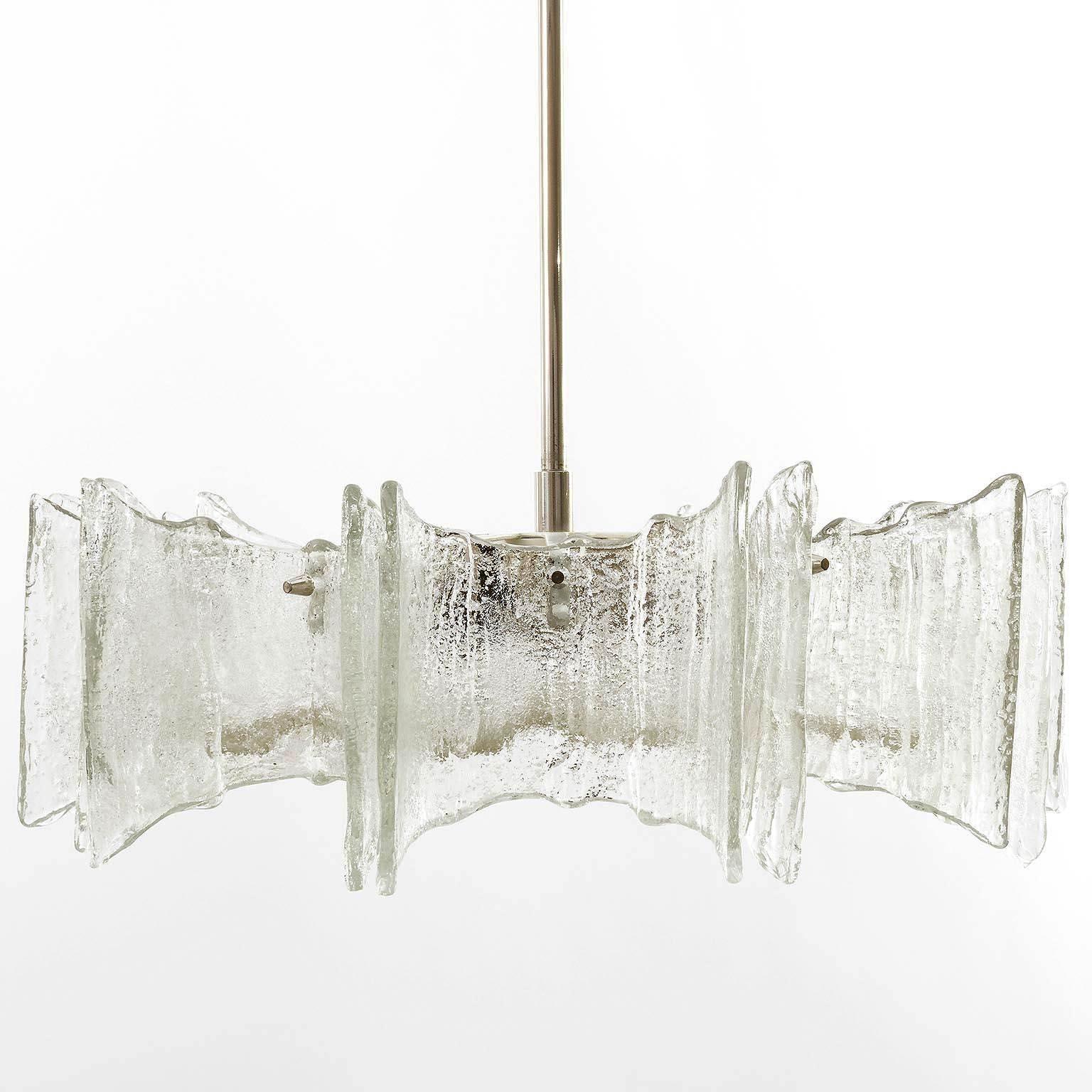 A star-shaped ceiling light by Kalmar manufactured in Austria in midcentury, circa 1970 (late 1960s or early 1970s). 
The lamp is made of frosted ice glass pieces mounted on a white lacquered frame and a nickel-plated brass stem and canopy.
It is