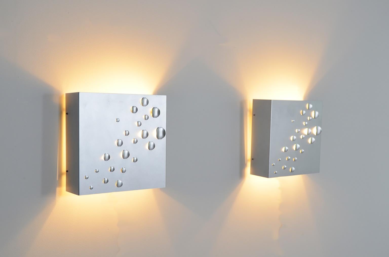 These 1960s metal wall sconces also known as model C1624 were designed by Jelle Jelles for RAAK, Amsterdam. The perforated metal brings a spectacular light effect. No wonder the name of the lamp is Star shower.