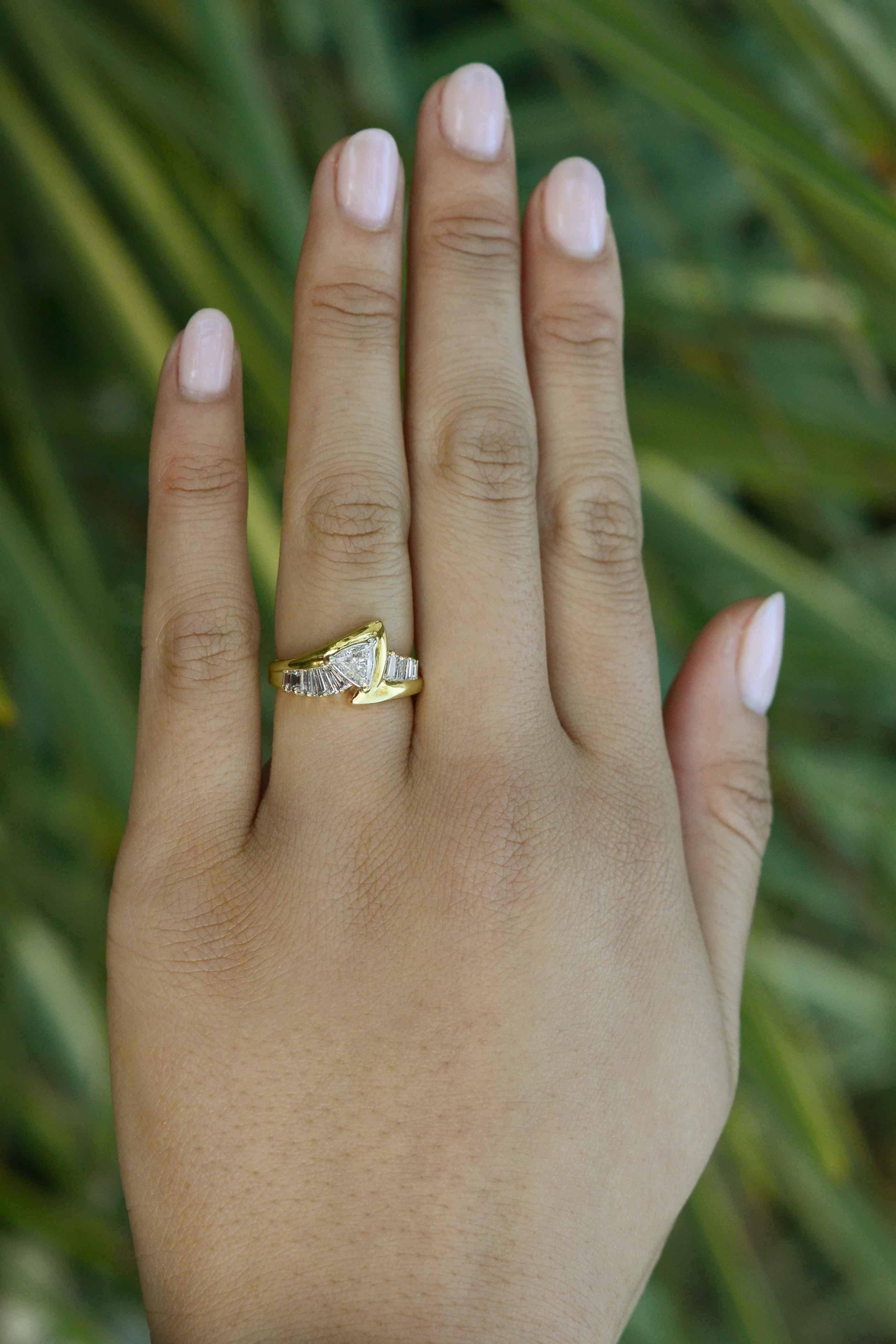 The Trekkie engagement ring of your dreams! Centered by a unique, fiery triangular shaped (trillion) diamond, this ring evokes the styling of the iconic Star Trek series with its signature yellow gold configuration flanked by tapered baguette