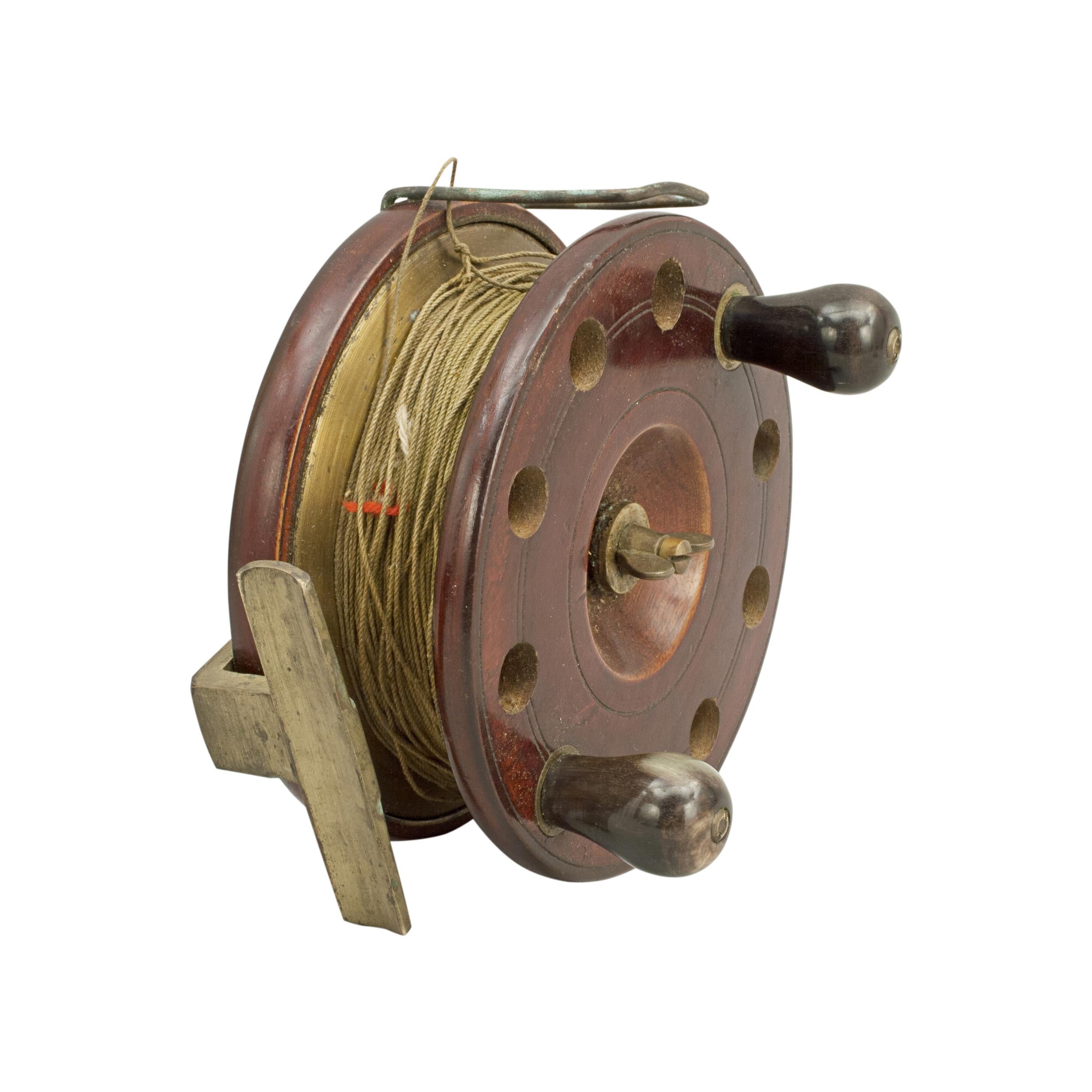 Vintage wooden fishing reel.
A fantastic centre pin Starback Neptune fishing reel. The front plate with cut out holes and two horn handles. The walnut reel with optional check, brass back plate, central tension screw and line guard.