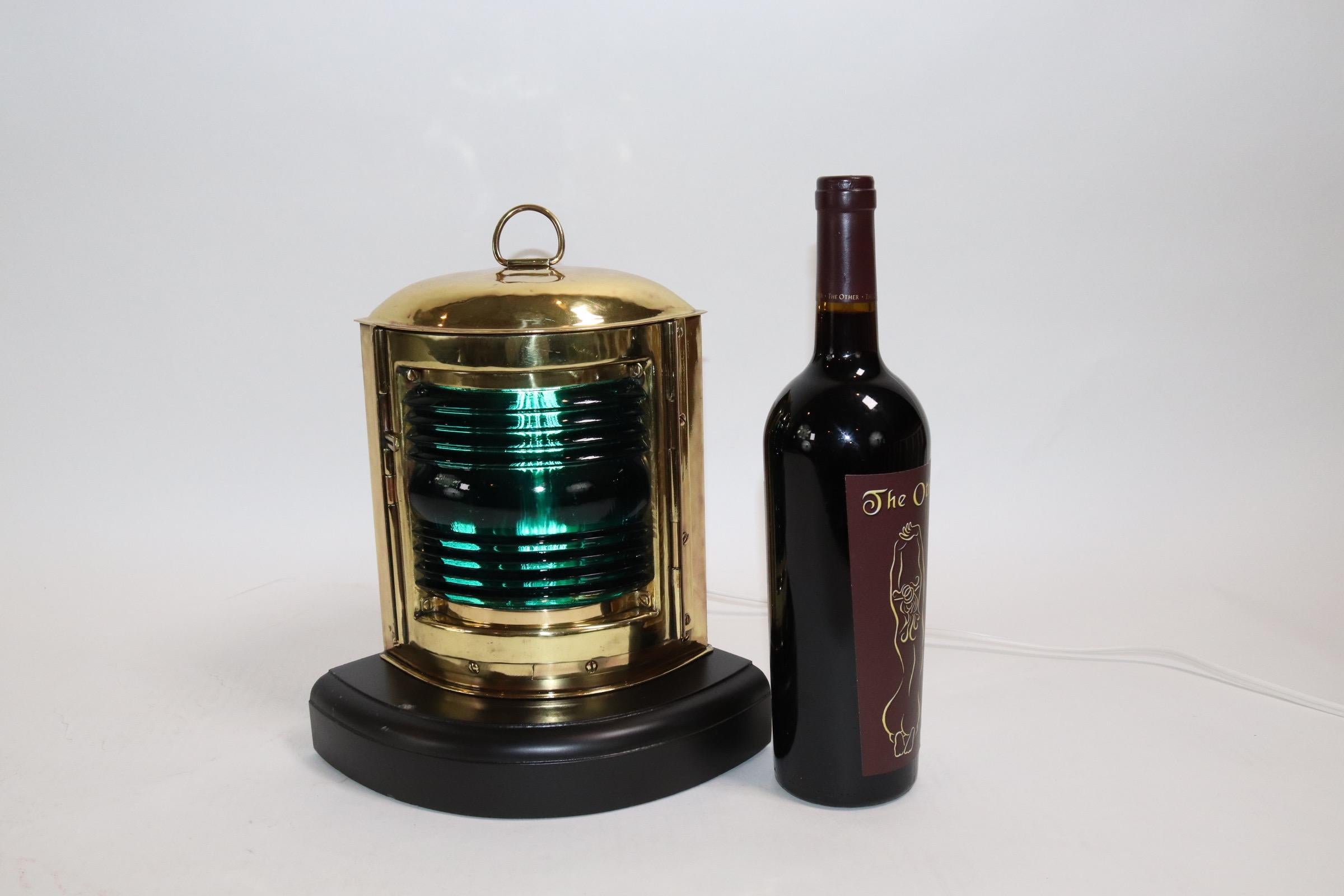 Starboard boat lantern with highly polished and lacquered finish and mounted to a thick wood base with routed edge. Lantern has been wired for home display. Weight is 4 pounds.