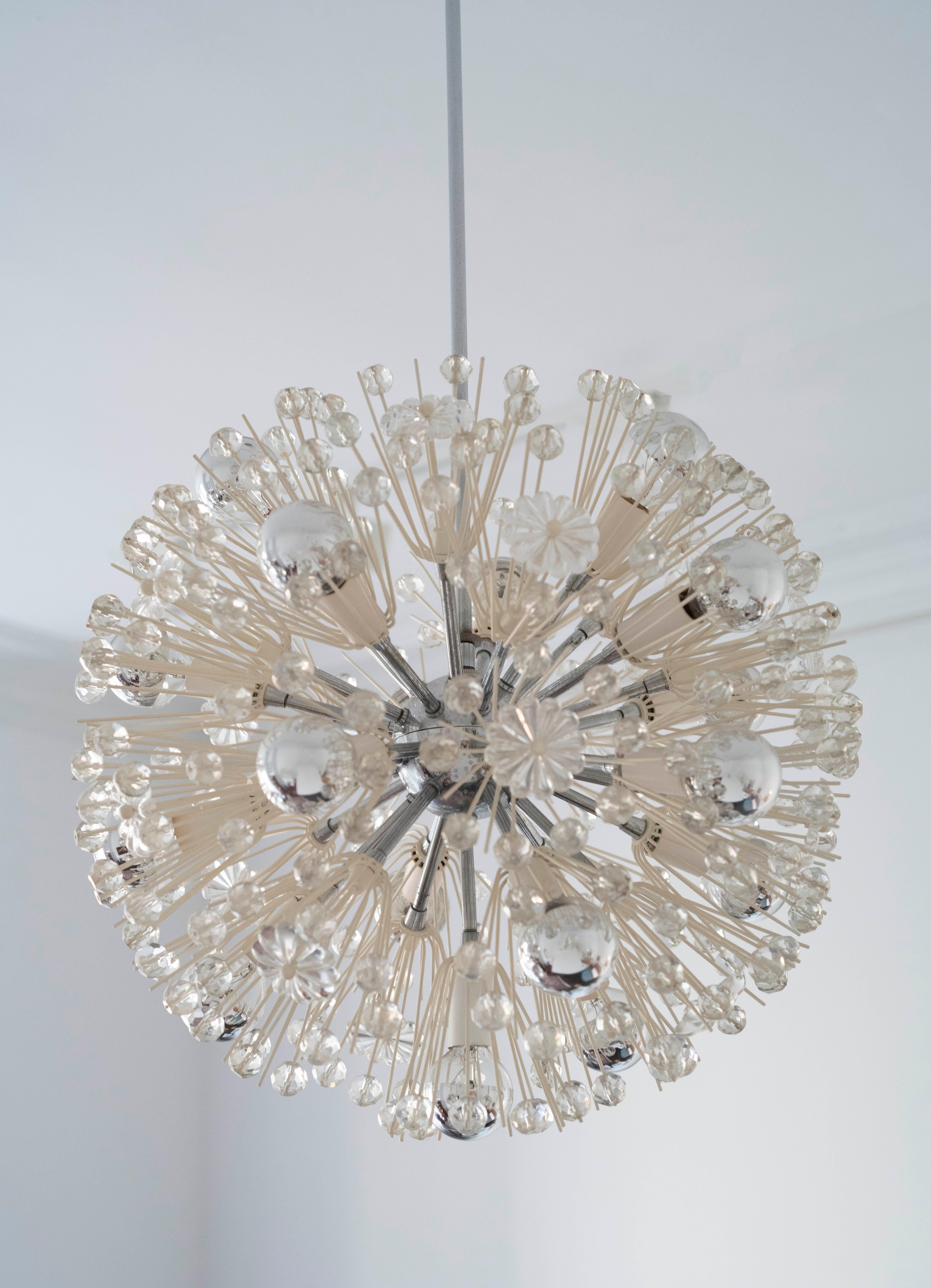 Beautiful 1960s modern starburst chandelier by Emil Stejar. Made with detailed crystal flowers and cut crystal spheres emanating from a brass and chrome core. There are seventeen lights that help create dazzling patterns and shadows on the nearby