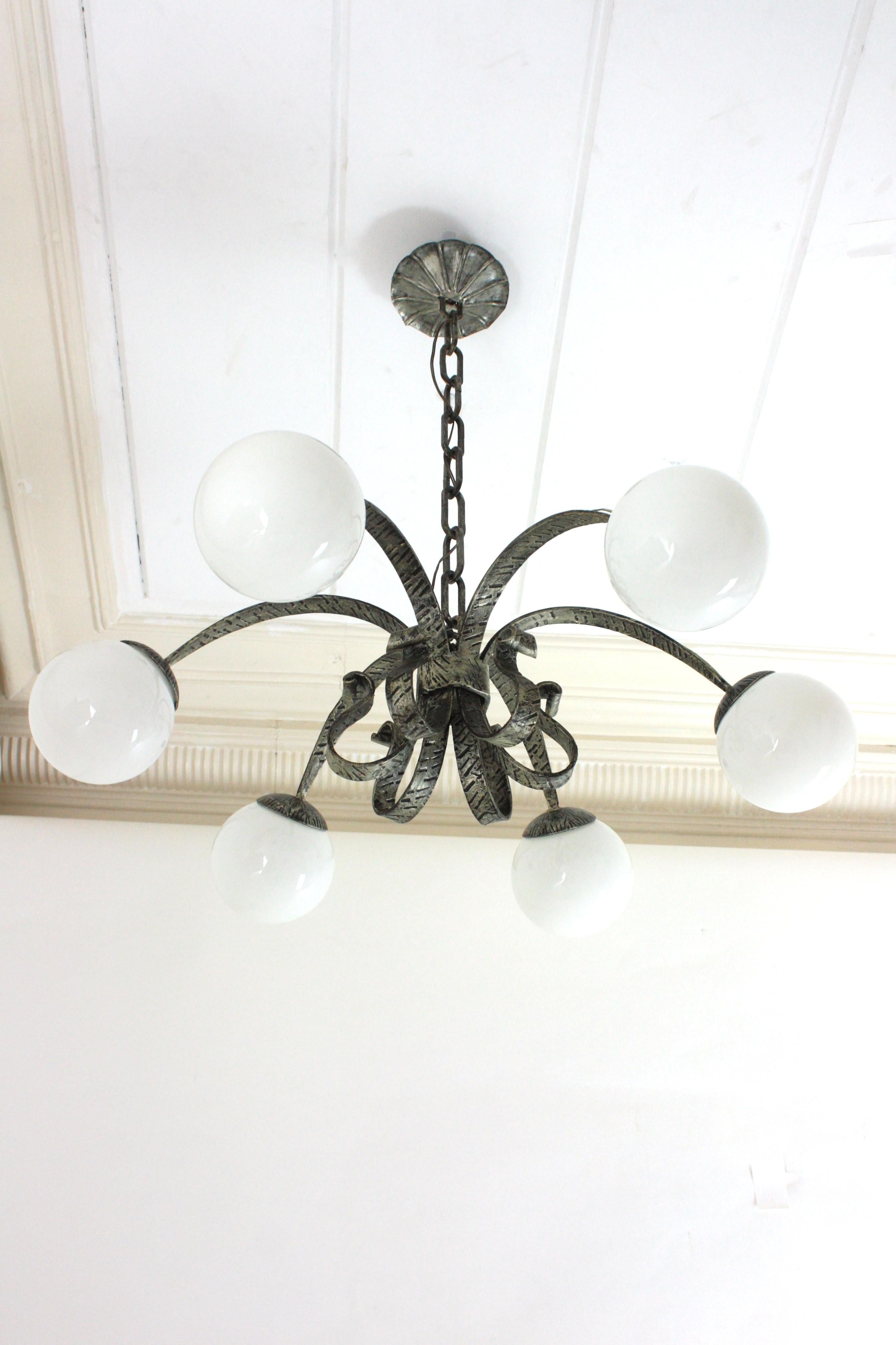 Grand lustre espagnol en forme d'étoile avec 6 globes en verre au lait, feuille d'argent, fer forgé
Magnifique lustre / plafonnier encastré en verre Sputnik en fer doré à la feuille d'argent.
Fabriqué par Ferro Art, Espagne, années 1950.
Grande