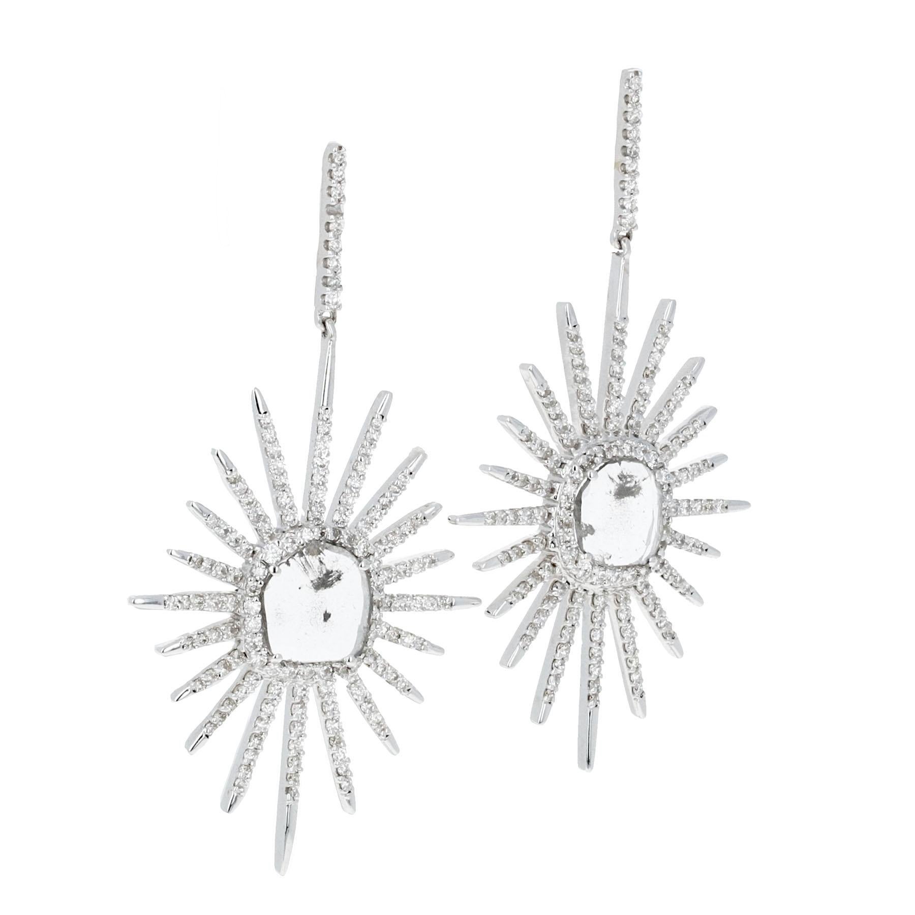 Starburst diamond dangle earrings are crafted in 14k white gold with a radiant rose-cut diamond center. The centerpiece is surrounded by a halo of micro pavé diamonds, with starburst rays embellished in sparkling diamonds for added brilliance. The