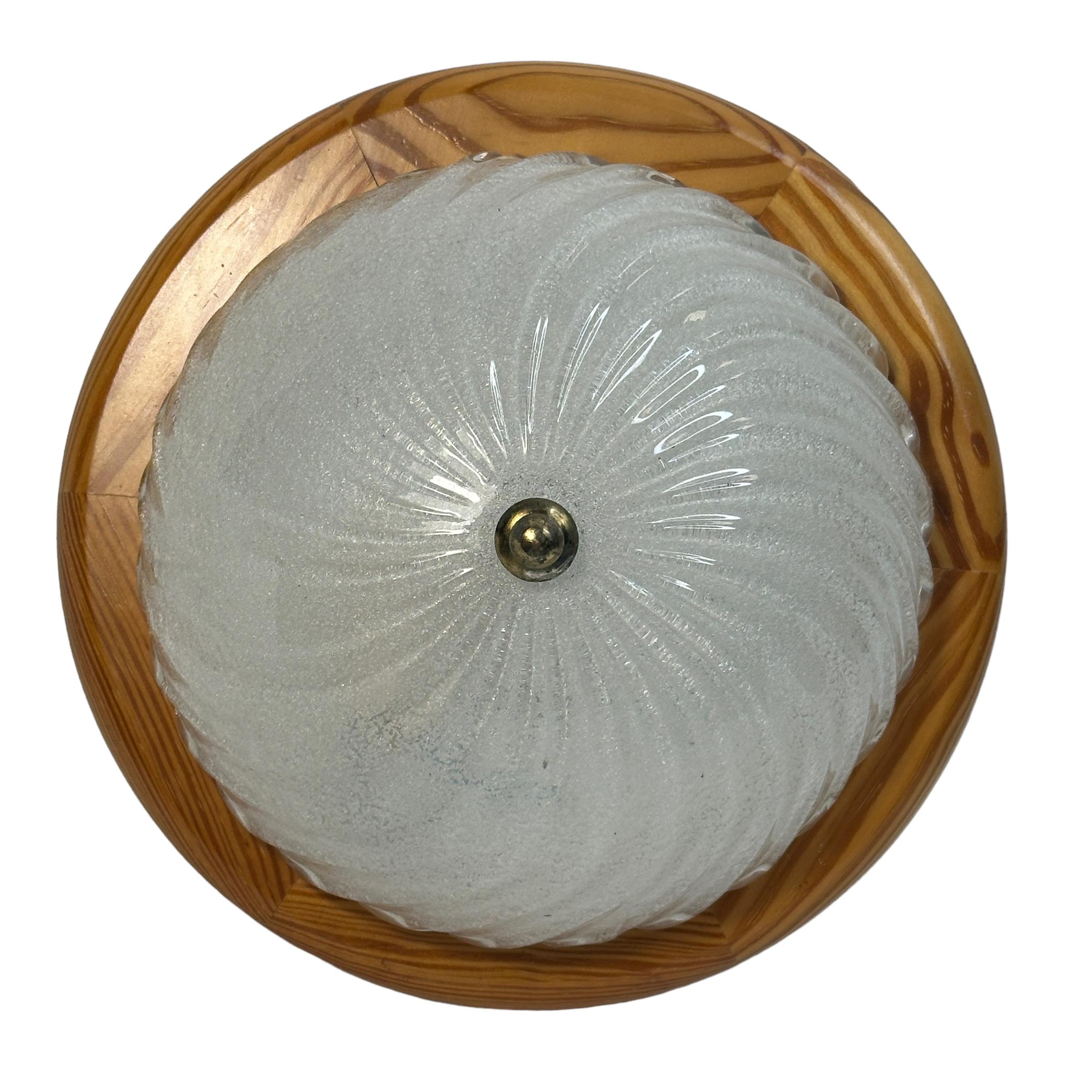 A beautiful ice glass flush mount. Made in Austria in the 1970s. Gorgeous textured glass flush mount with metal fixture and a wooden frame. The Fixture requires one European E27 / 110 Volt Edison bulb, up to 60 watts. A nice addition to any room.